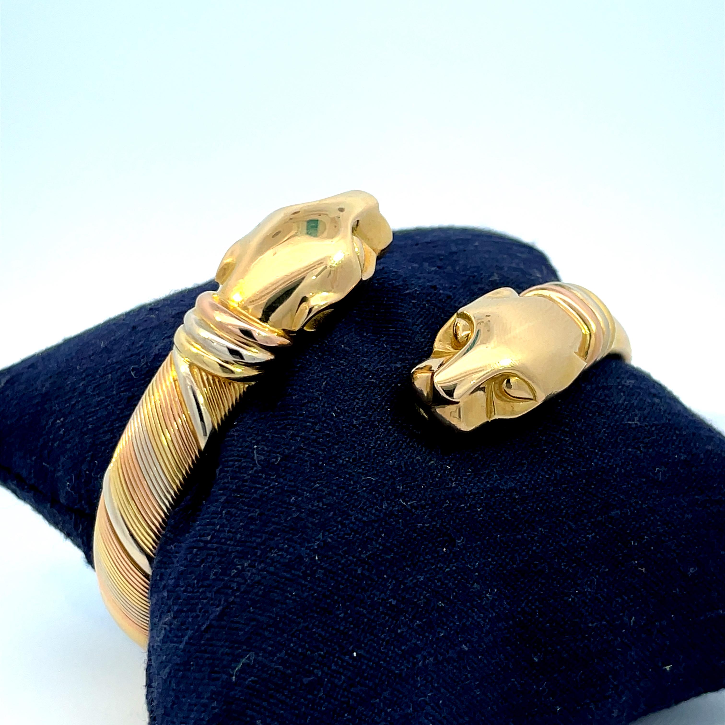 A beautiful vintage 1980’s Panthère de Cartier bangle set in stainless steel and 18k tri coloured gold.

This incredibly stylish bangle is composed of two solid yellow gold panther heads. These heads are connected to a coiled yellow gold bangle