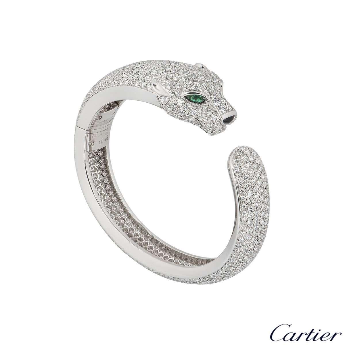 An exquisite 18k white gold diamond, emerald and onyx Cartier bracelet from the Panthere De Cartier collection. The bracelet features the iconic panther head motif set with 2 emerald eyes and an onyx nose. The bracelet is fully set with 706 pave