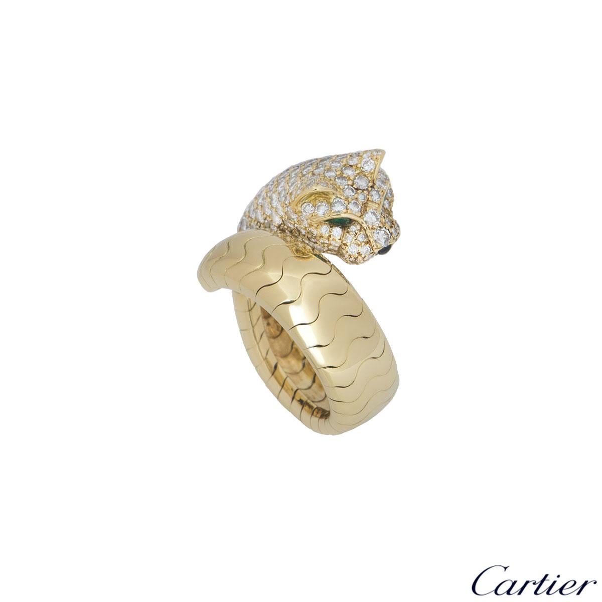 A beautiful 18k yellow gold ring by Cartier from the Panthere De Cartier collection. The ring comprises of a panther head motif with 158 round brilliant cut diamonds pave set with a weight of 2.07ct, F+ colour and VS+ in clarity, with two emeralds
