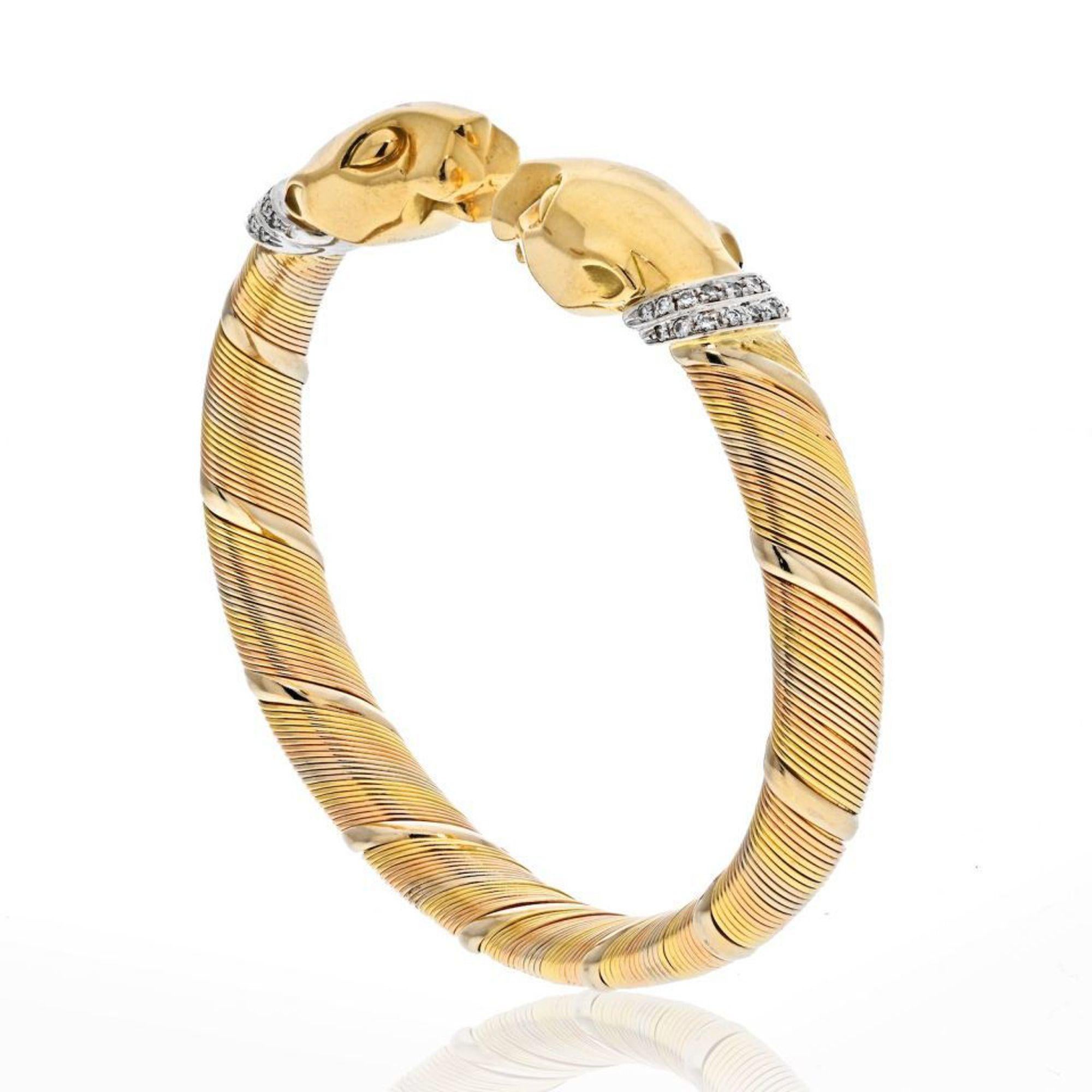 Rare vintage Panthere De Cartier (Cougar) bangle bracelet crafted in coiled tri-color 18k gold. This bracelet features two solid yellow gold Panthere heads at each end. The bangle is a 'half flexible' bracelet which makes it easy to take on and off,