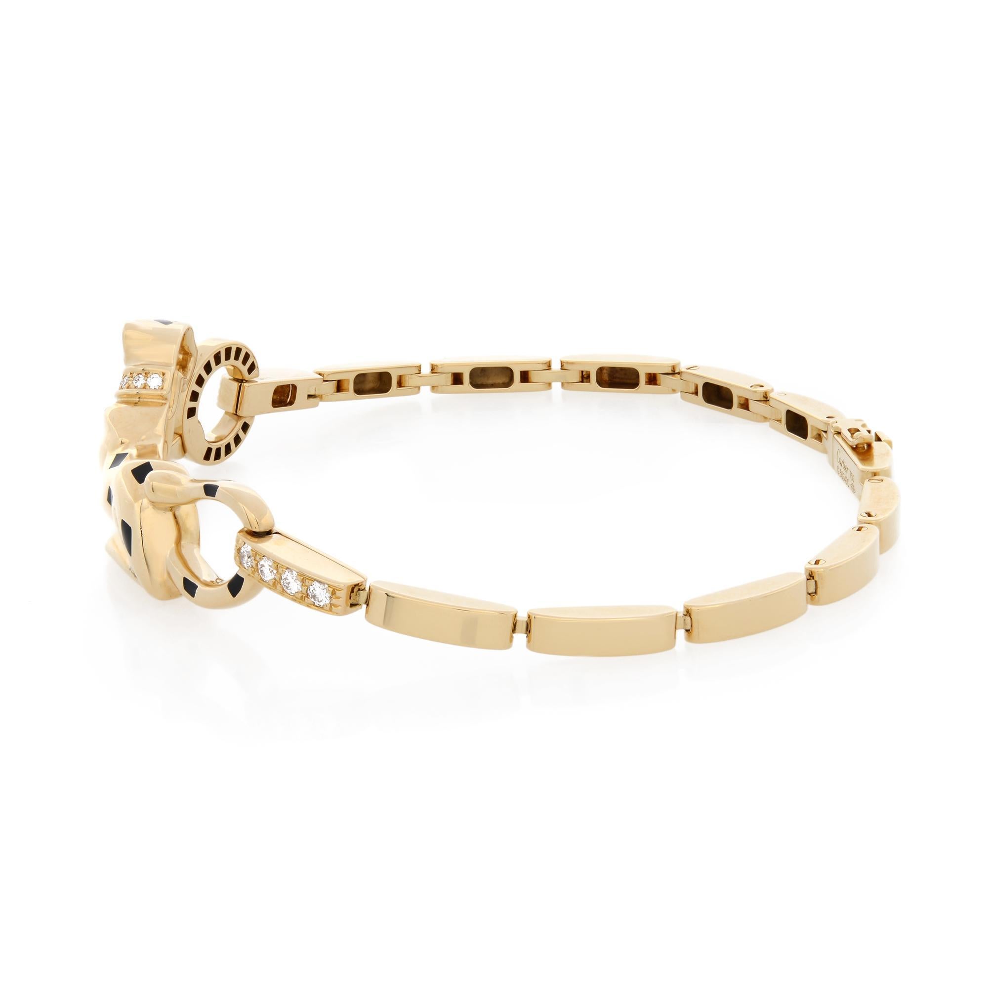 An iconic Cartier Panthere de Cartier bracelet in 18K yellow gold. This bracelet features 31 brilliant cut glittering diamonds weighing 0.26 carats encrusting the Panthere's neck and connecting rings. The eyes are set with tsavorite garnet stones
