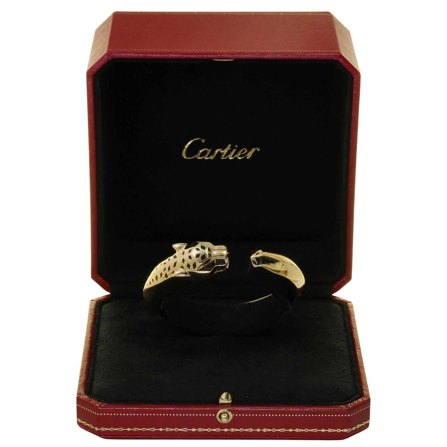 Ce fabuleux bracelet Panthère de Cartier présente le design iconique de la panthère en or jaune 18 carats, rehaussé d'yeux en grenat tsavorite vert, d'un nez en onyx noir et de taches en laque noire. Fabriqué en France dans les années 2010.
