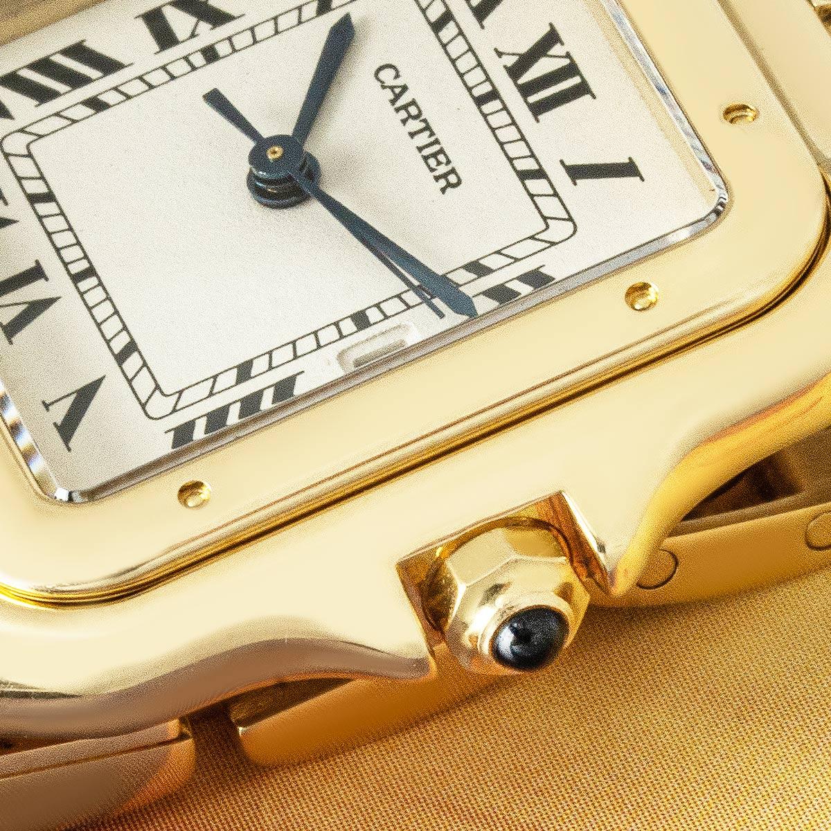 Eine mittelgroße Panthère de Cartier-Armbanduhr aus Gelbgold von Cartier. Sie verfügt über ein silbernes Zifferblatt mit Datumsanzeige, römischen Ziffern, schwertförmigen Zeigern aus gebläutem Stahl und einer geheimen Cartier Signatur bei VII. Das