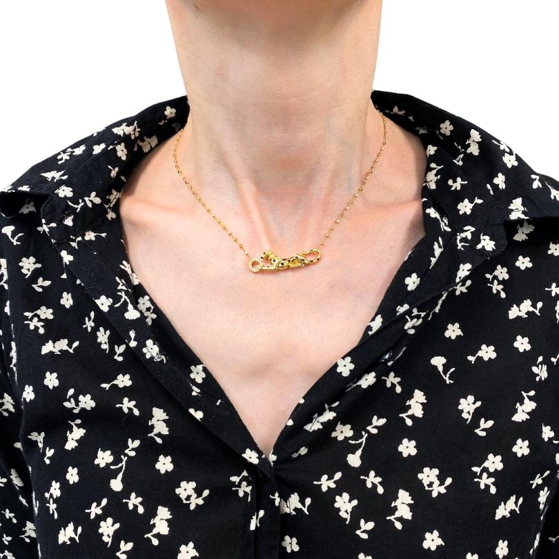 Collier pendentif Panthère de Cartier en or jaune 18 carats. Le pendentif présente le motif emblématique de la Panthère, rehaussé de diamants pavés et d'yeux d'émeraude hypnotiques. Le design souligne la précision du travail de Cartier et