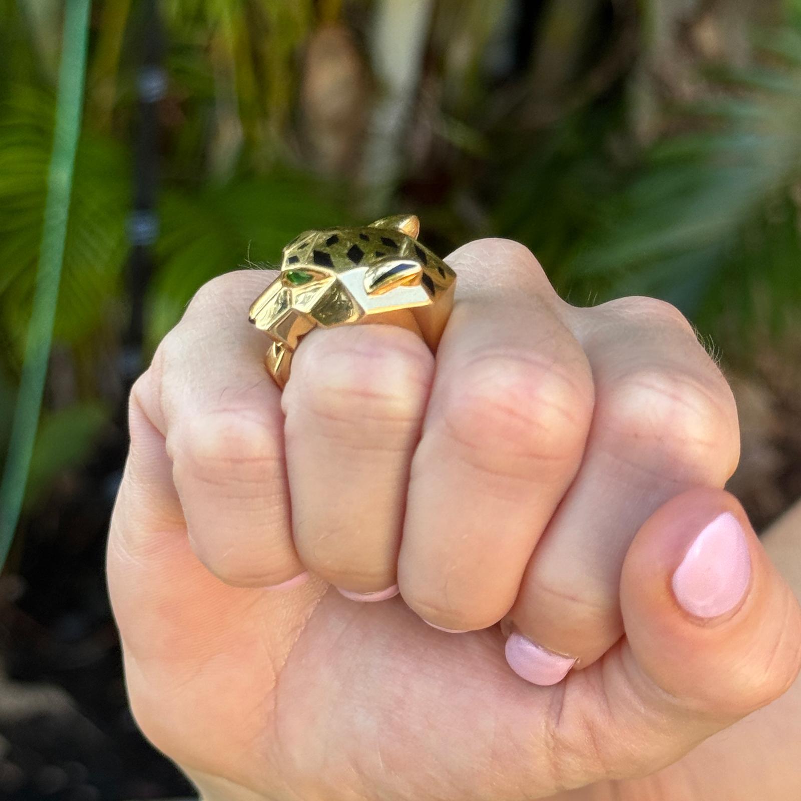 This Cartier Panthère de Cartier ring is crafted in 18K yellow gold and features the collection’s signature panther motif with onyx and tsavorite garnet accents, capturing the elegance and mystique of the feline design. It comes complete with the