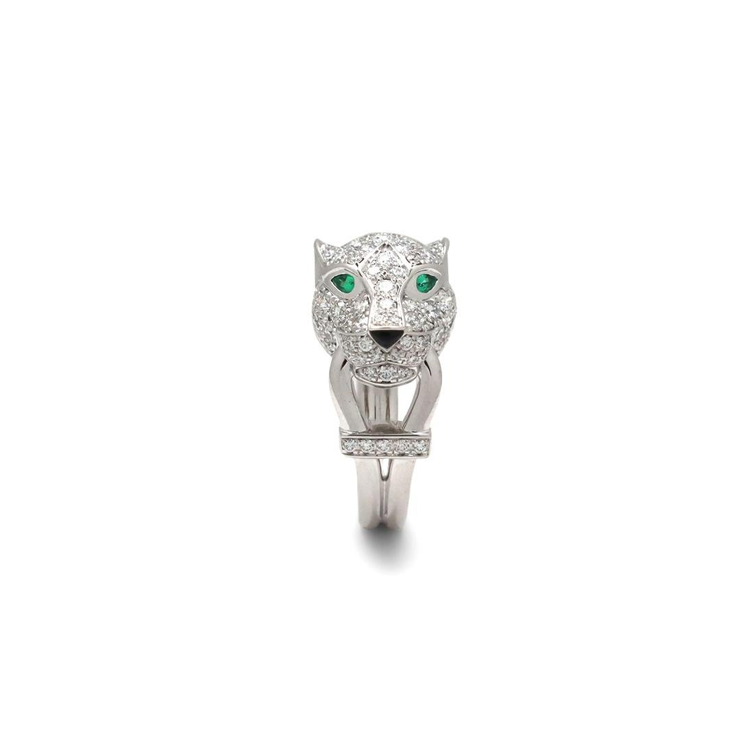 Authentic Panthère de Cartier ring crafted in 18 karat white gold and set with approximately 0.75 carats of round brilliant cut diamonds throughout the head of the panther. The panther head is completed with emerald eyes and a carved black onyx
