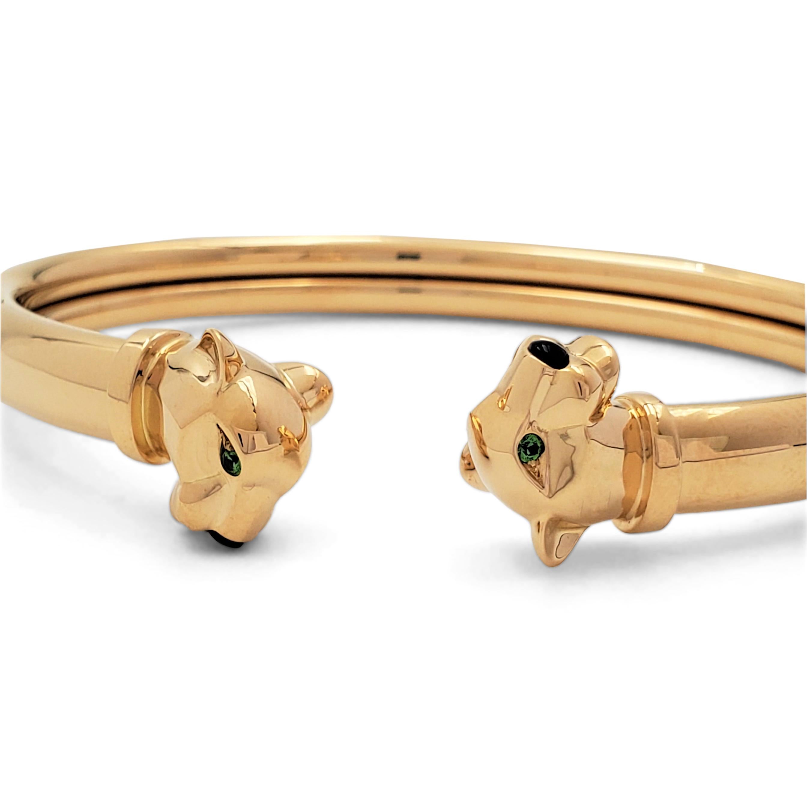 Authentic Cartier Panthère de Cartier bracelet crafted in 18 karat yellow gold. Each panther head is set with lively tsavorite garnet eyes and an onyx nose. Signed Cartier, 16, Au750, with serial number. The bracelet is presented with the original