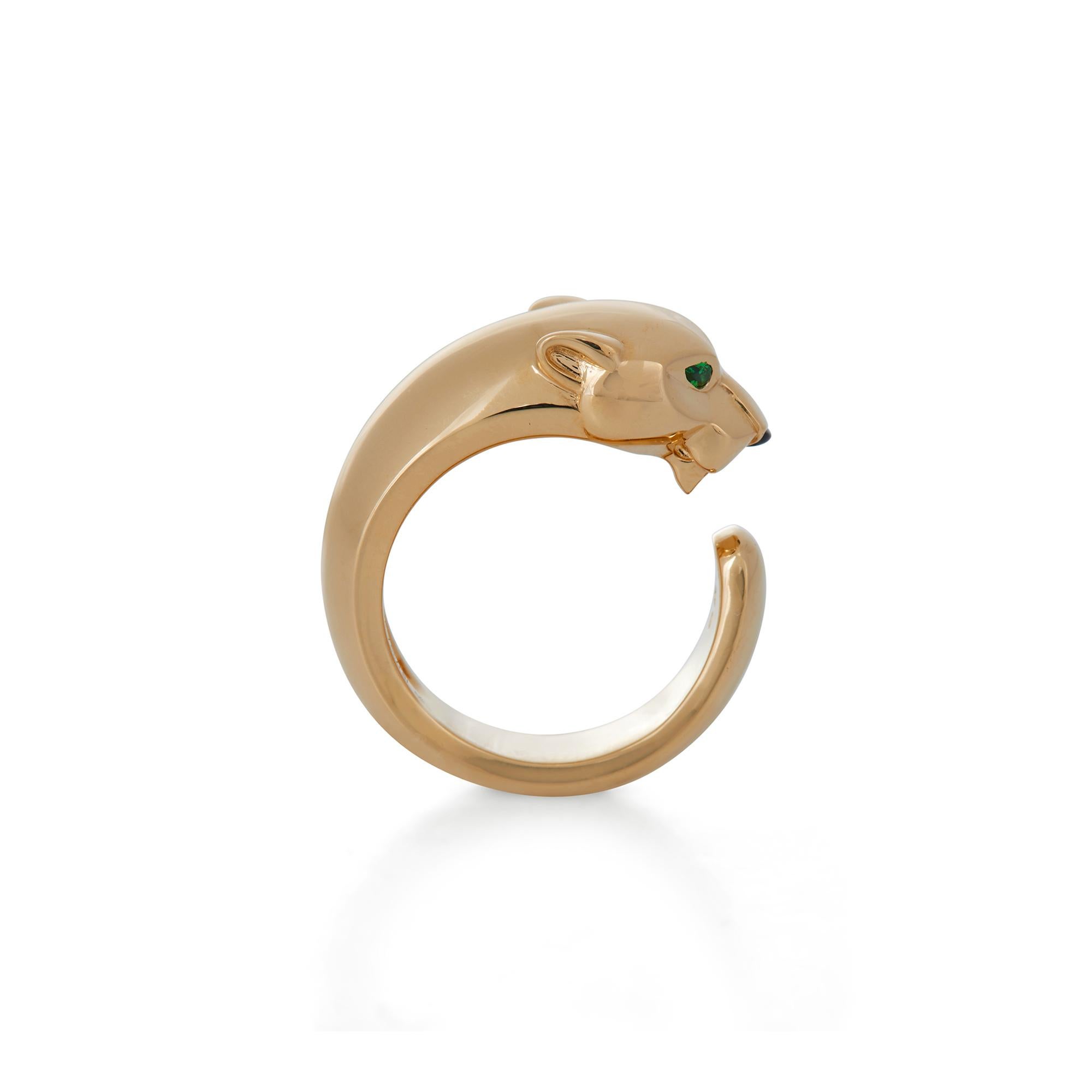 Authentic Panthère de Cartier ring crafted in 18 karat yellow gold. The panther head motif is set with tsavorite garnet eyes and a carved onyx nose and measures 11mm in width.  Size 51, US 5 3/4.  Signed Cartier, 51, Au750, with serial number and