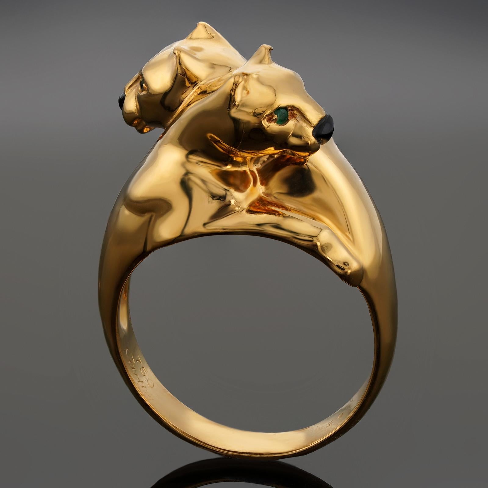 Dieser wunderschöne, authentische Cartier-Ring aus der kultigen Panthere de Cartier Collection ist aus 18 Karat Gelbgold gefertigt und zeigt ein ineinander verschlungenes Doppelpantherkopf-Design, das mit einer schwarzen Onyxnase und grünen