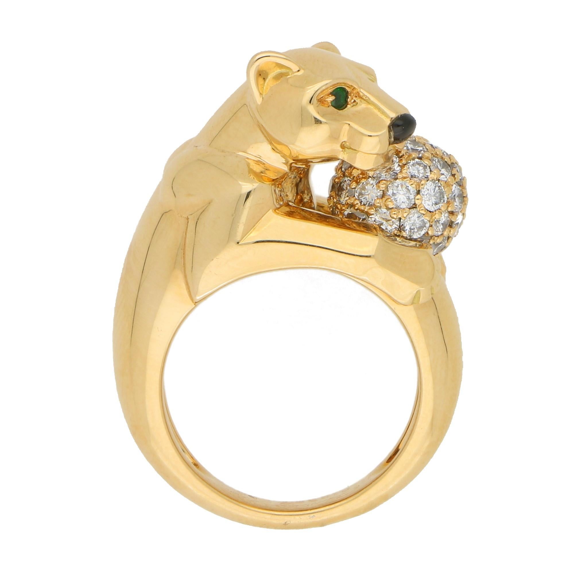 A classic Cartier Panthère ring set in solid 18 carat yellow gold. The ring prominently features a polished panther shaped motif which holds a pave set diamond ball. The panther is set with vibrant emerald green eyes and an onyx nose.

The beauty of