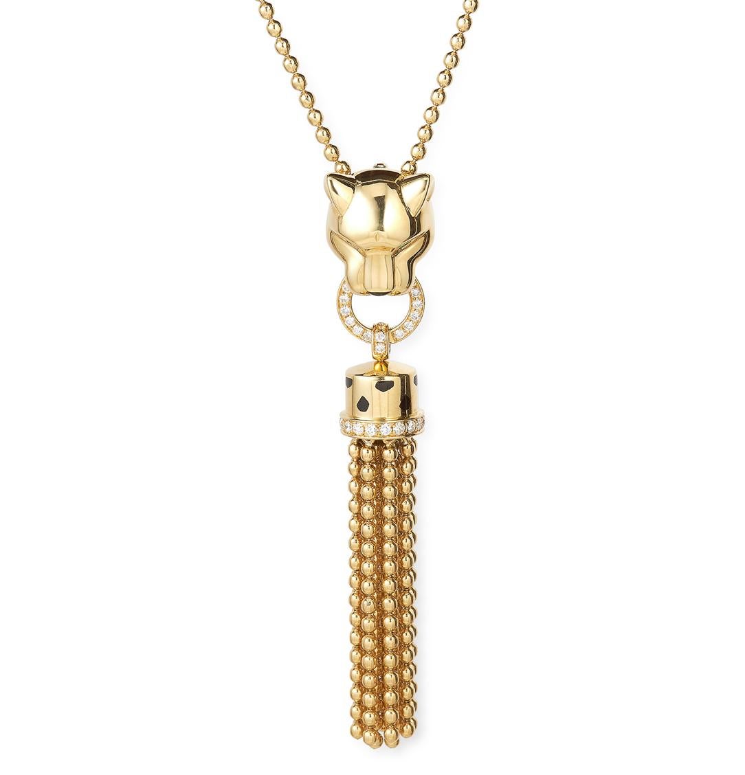 A Cartier “Panthère de Cartier” Diamond Pendant Necklace in 18 Karat Yellow Gold, French, 2000s. This iconic jewel is designed as a panther's head with tsavorite garnet eyes biting a pendant composed of an open hoop and a gold bead tassel, set with