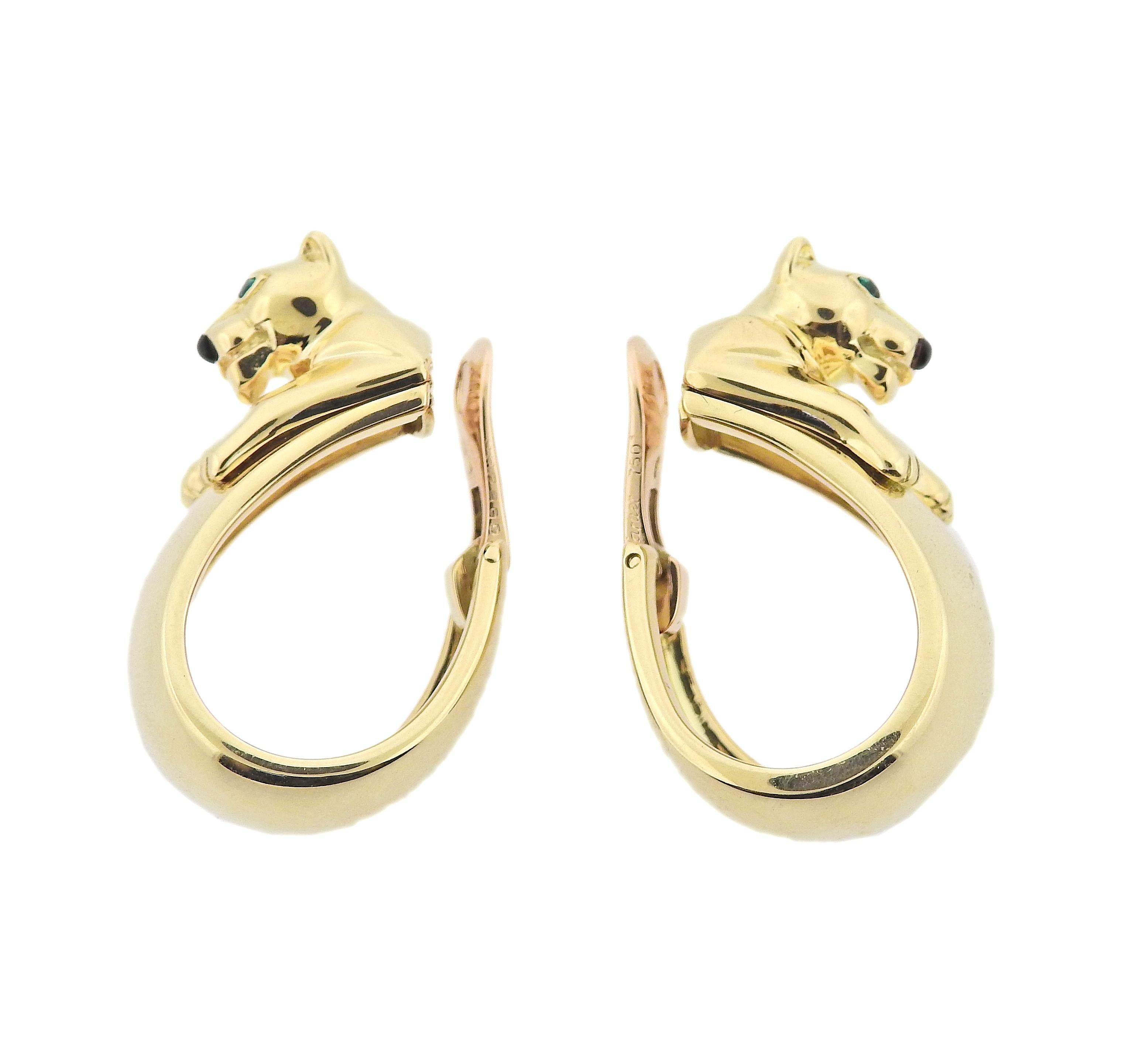 Pair of classic Panthere hoop 18k gold earrings by Cartier, with emerald eyes and onyx nose. Earrings are 35mm x 15mm. Marked 622899, Cartier, 750. Weight 43.3 grams. 