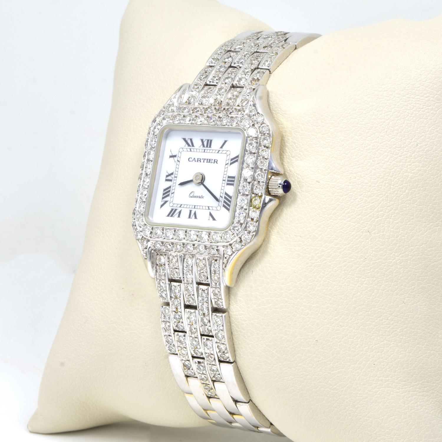 Brand: Cartier

Model: Panthere

Reference: 1320

Case: 22mm with Aftermarket Diamond Bezel

Dial: White Dial with Roman Numeral Index

Stones: Diamonds

Carat total weight: Approx. 3 ctw

Bracelet: Fitted on a 18k White Gold Bracelet with
