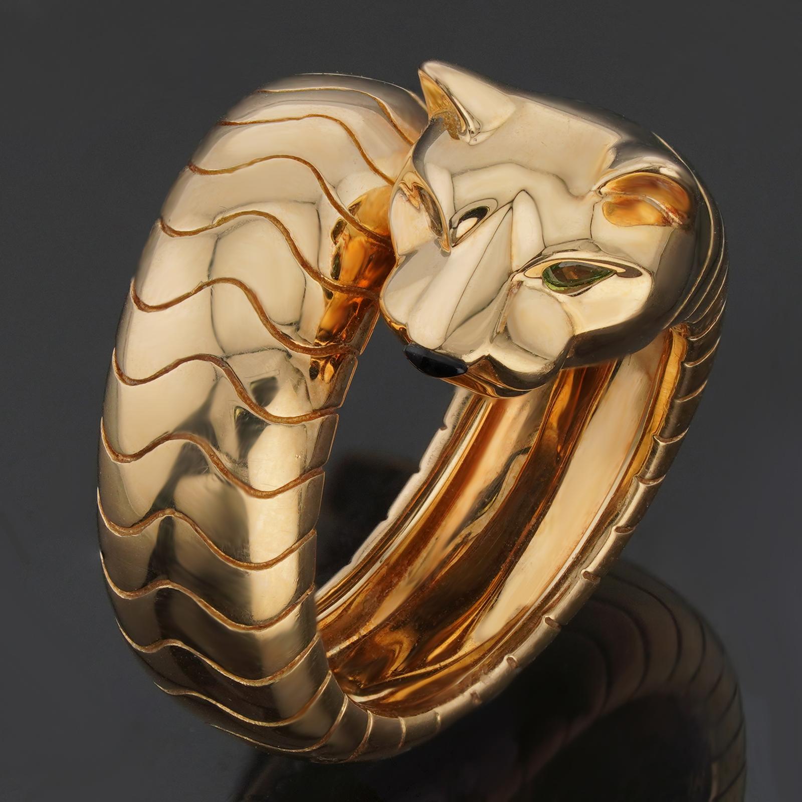 This gorgeous Cartier ring from the Panthere La Carda collection features a panther design crafted in 18k yellow gold and set with a black onyx nose and green Tsavorite eyes. Made in France circa 1990s. Measurements: 0.78