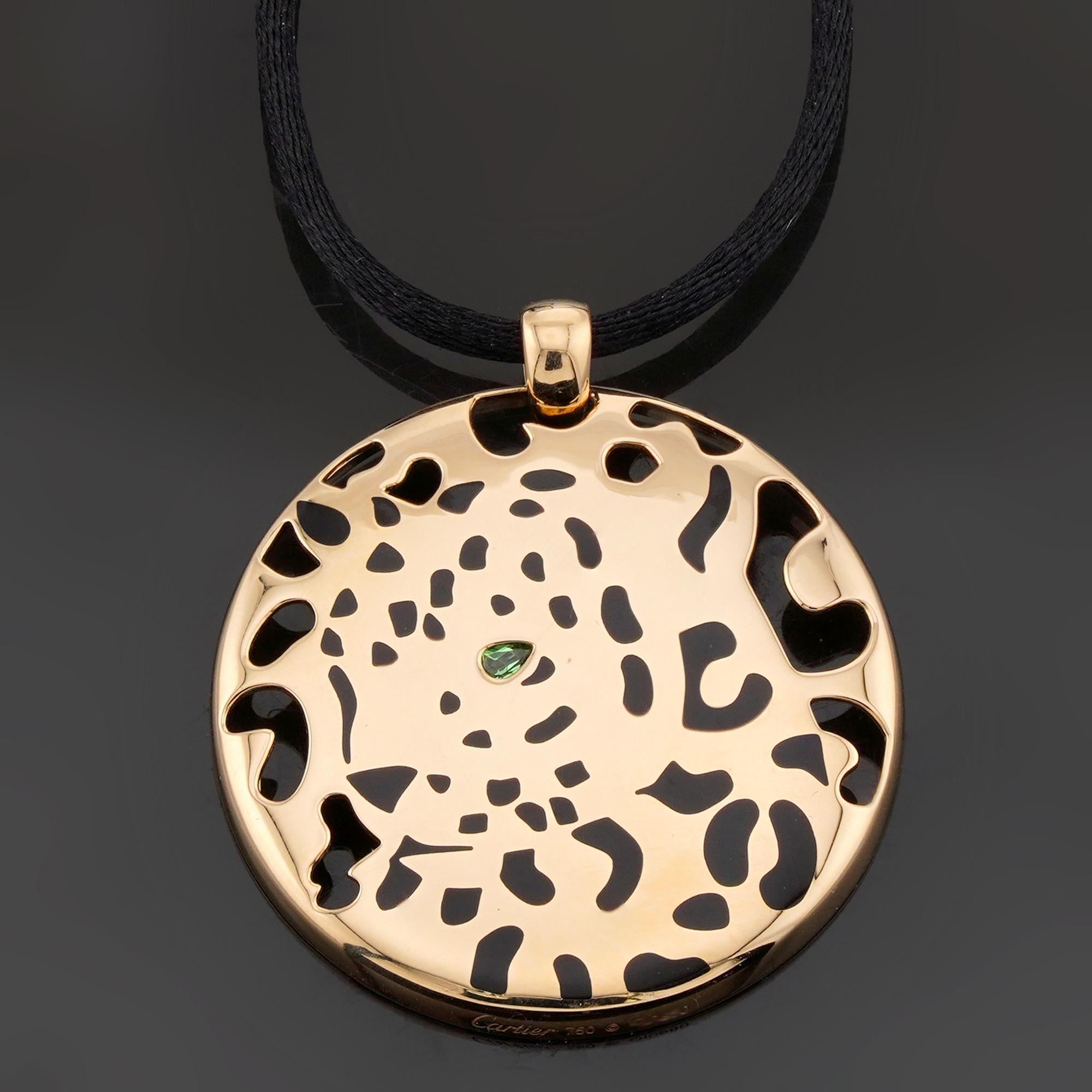 Questa splendida collana Cartier Panthere è caratterizzata da un disco rotondo realizzato in oro giallo 18 carati e impreziosito da macchie di lacca nera e da una tsavorite verde, completata da un cordoncino di seta nero regolabile. Realizzato in