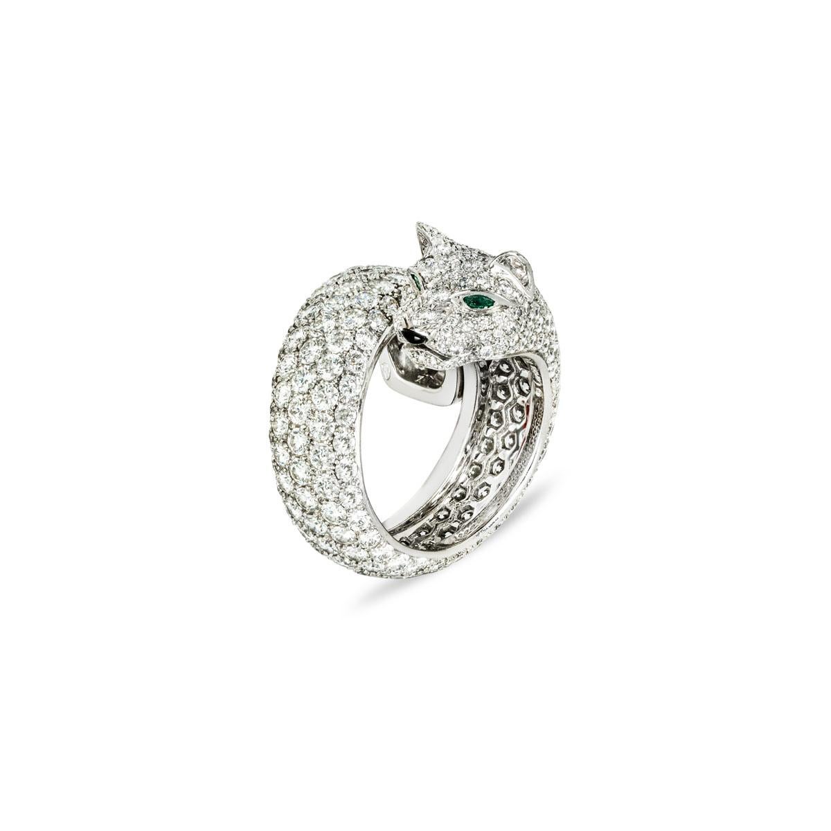 Impresionante anillo de diamantes Lakarda Panthere de Cartier de oro blanco de 18 quilates de la colección Panthere de Cartier. El anillo de estilo envolvente consta de un motivo de pantera con ojos de esmeralda, nariz de ónice y cuerpo de