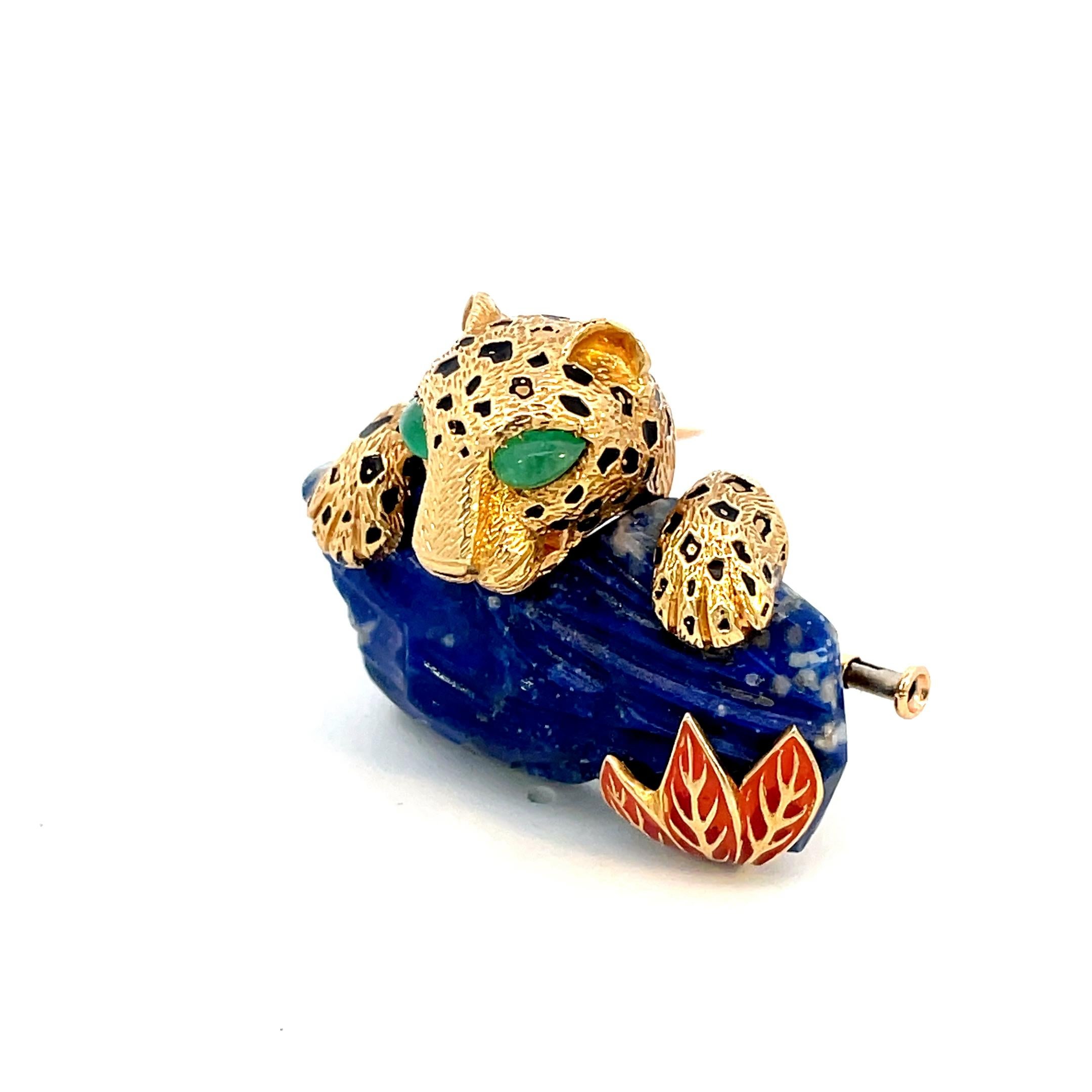 Unique 1973 Cartier Panthere Brooch designed as a panther swimming in water, with cabochon emerald eyes and black enamel spots, to the carved lapis lazuli highlighted with red enamel leaves, mounted in 18 karat yellow gold, signed Cartier, numbered,