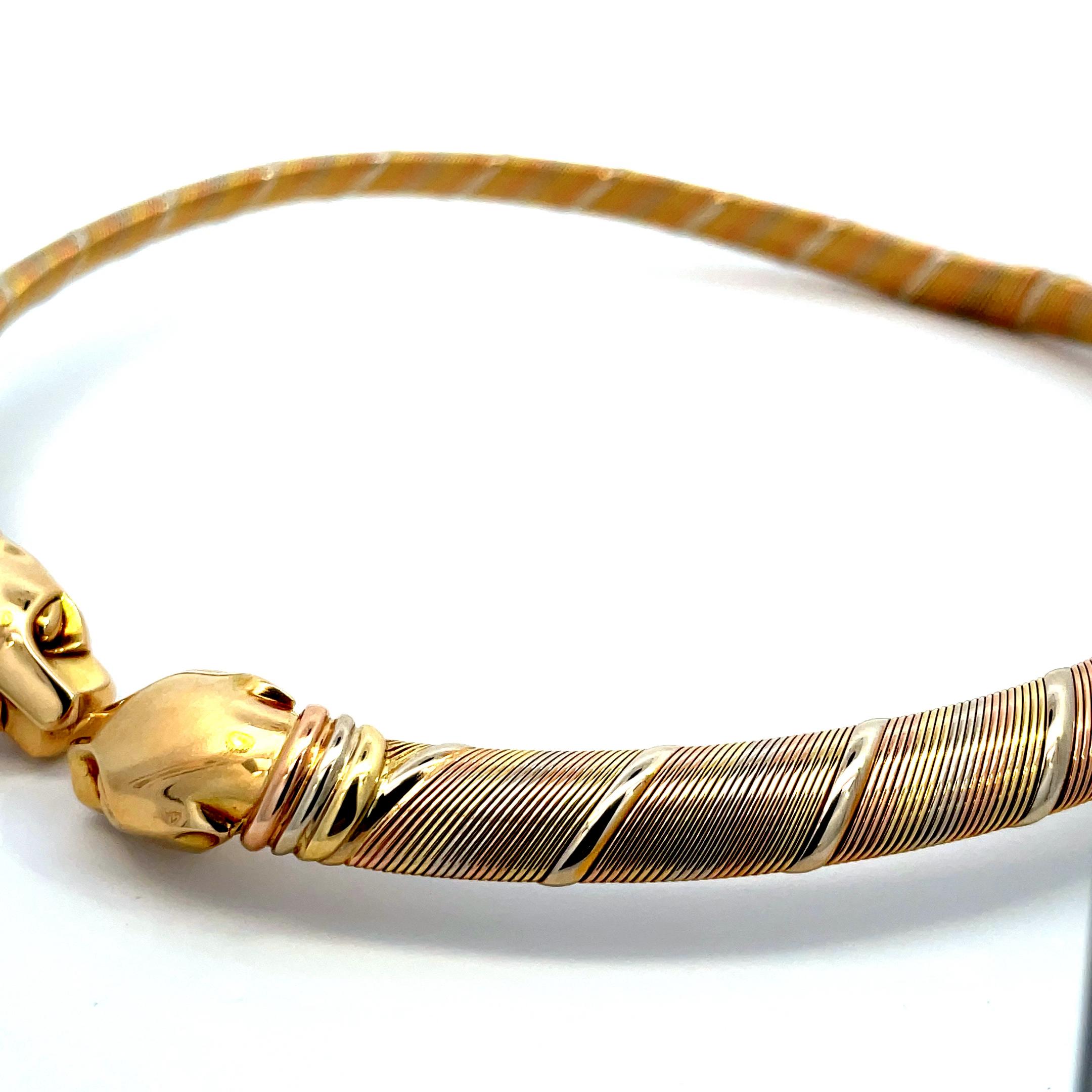 A Rare 3 Gold 'Panther' Necklace
Designed as a collar necklace of rigid Gold accented by bands of polished gold, to the panther head terminals enhanced by tri-color gold collars, mounted in  18K yellow, white, and rose gold.
Signed 'Cartier',