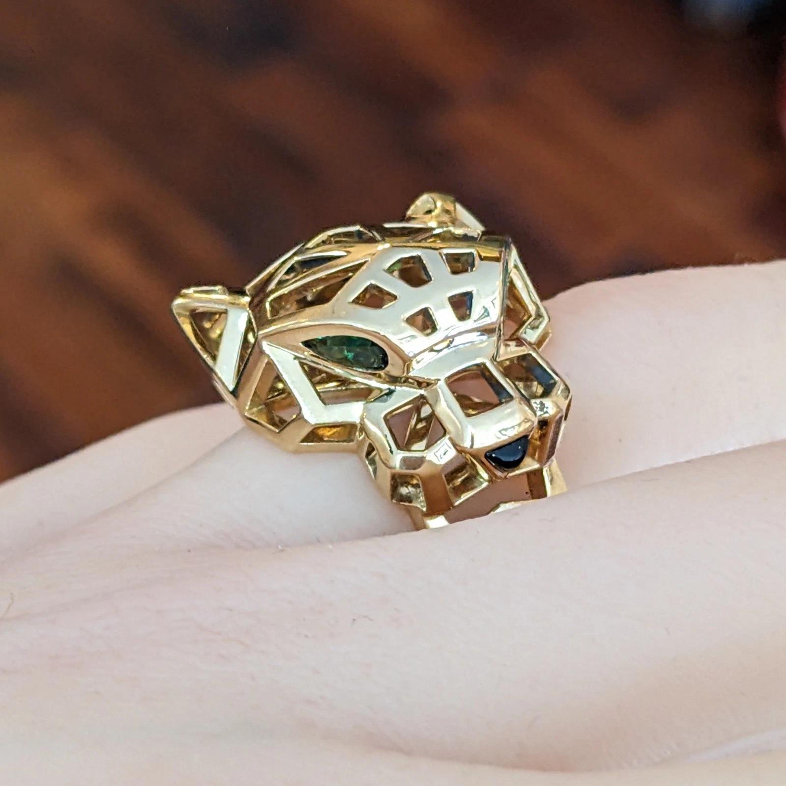 Anello Cartier Panthere, misura 51 in oro giallo 18 carati 

L'anello Panthere di Cartier presenta un anello Panthere de Cartier a lavorazione aperta con testa di Panthere in oro giallo 18 carati, incastonata con grani di tsavorite verde per gli