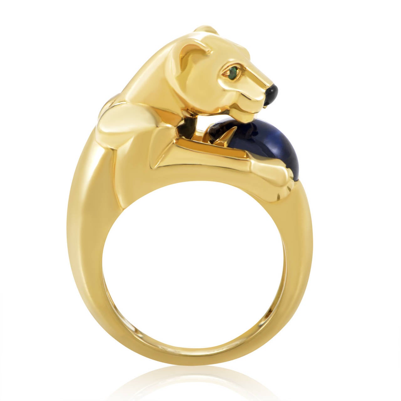A brilliant blue sapphire is the hallmark of this dazzling creation from Cartier's Panthere collection. The ring is made of 18K yellow gold and boasts a panther-shaped motif with green emerald eyes, an onyx nose, and a sapphire stone clutched in its