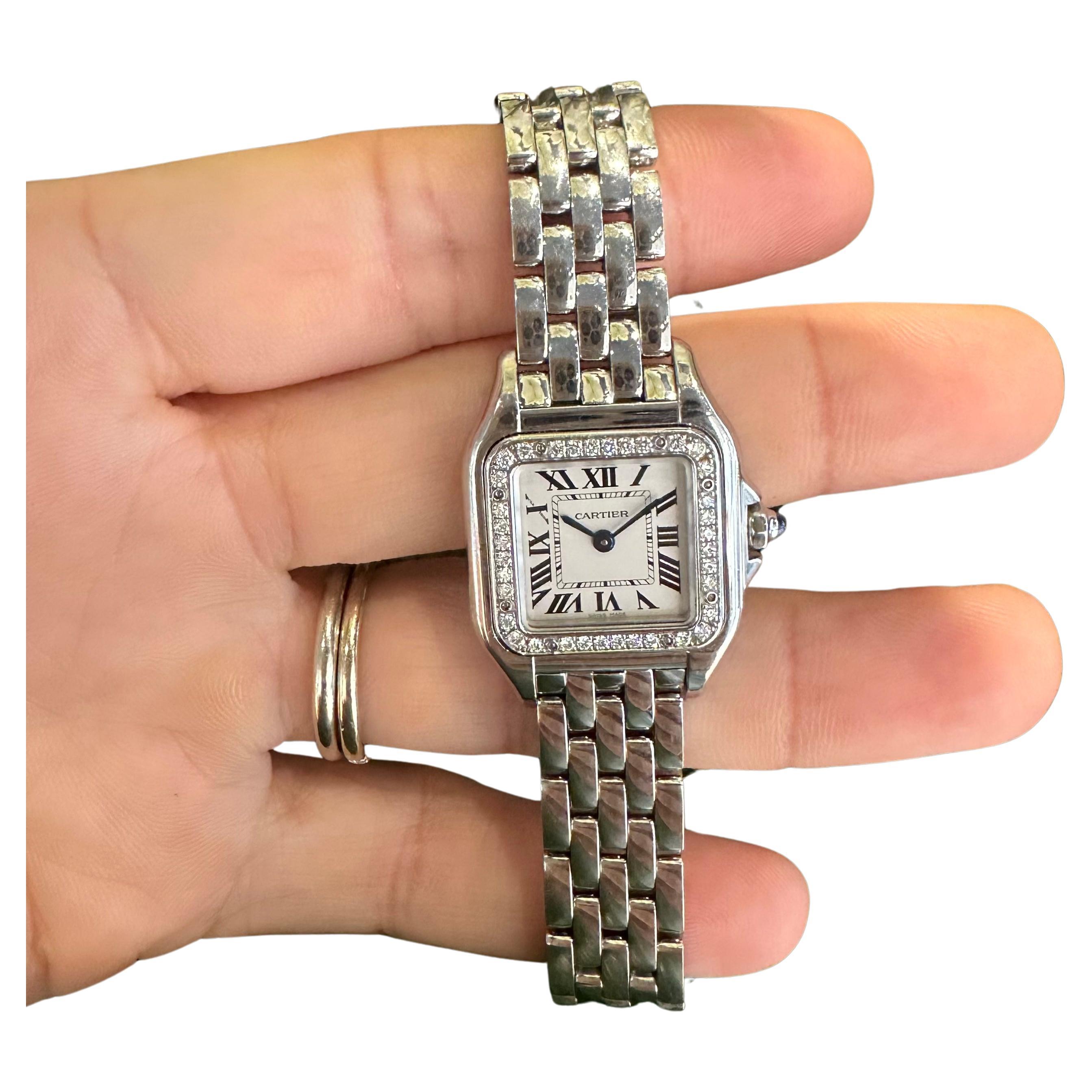 Brand: Cartier

Model: Panthere Small Model

Movement: Quartz

Stone: Round Brilliant Cut Diamonds

Case Size: 23mm x 30mm 

Material: Stainless Steel ​

Bezel: Diamond 

Crown: Synthetic Blue Spinel

Dial:  Silver 

Includes: 24 Month Brilliance