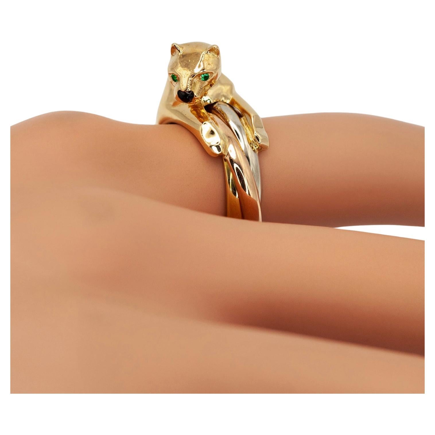 Cr�éation emblématique de Cartier, cette bague Panthère Trinity(Antrina) réunit deux des designs les plus légendaires de la Maison : la sculpturale Panthère et les intemporels anneaux Trinity. Réalisée en or tricolore 18 carats, la bague présente une