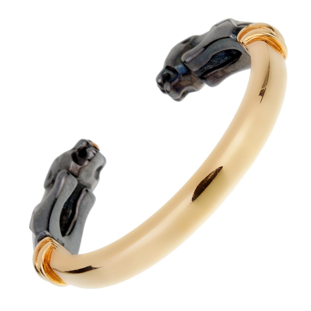 An 18k yellow gold and hematite cuff bracelet from the Panthere de Cartier collection. The bracelet is composed of 2 hematite Panther heads facing each other with 18k yellow gold eyes.