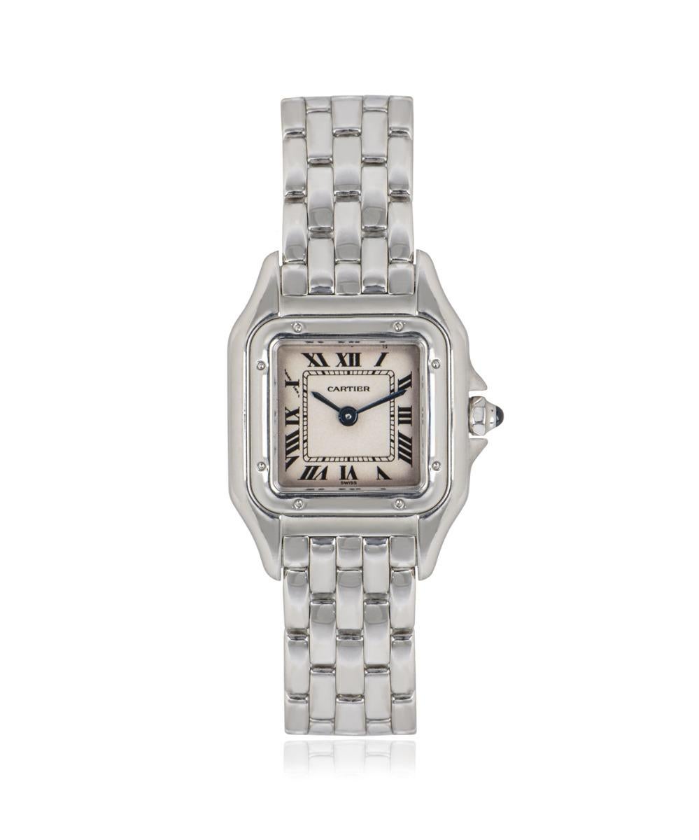 This Cartier 22mm ladies watch in white gold features a silver dial with roman numerals, blued steel sword shaped hands, and Cartier's own hidden signature at 'X'. This timepiece is fitted with a scratch resistant sapphire crystal, swiss quartz