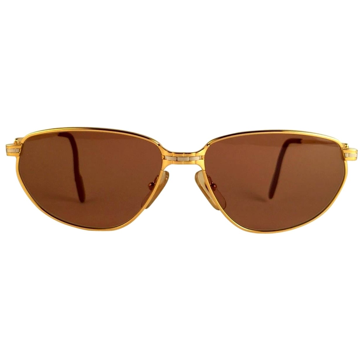 New 1988 Cartier Panthere Windsor Sunglasses with spotless brown(uv protection) lenses. The cat's eye frame is with the front and sides in yellow and white gold. All hallmarks. Red enamel ear paddles. 
Both arms sport the C from Cartier on the