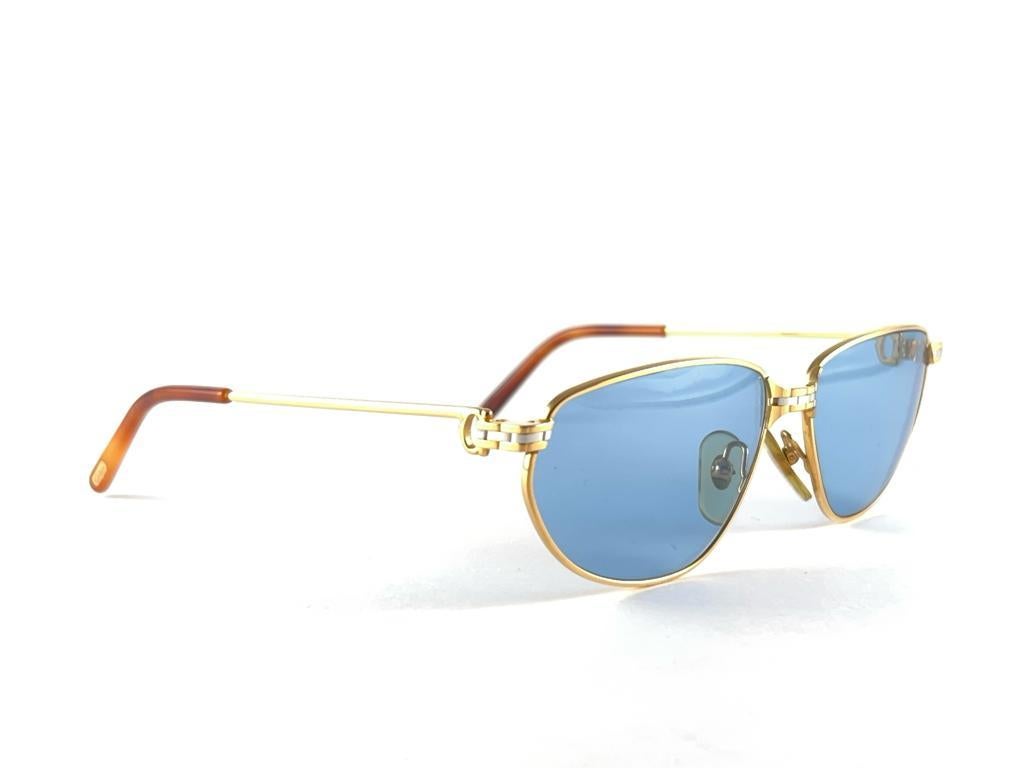 Vintage 1988 Cartier Panthere Windsor Sonnenbrille mit makellos blauen (UV-Schutz) Gläsern. Die Katzenaugenfassung ist auf der Vorderseite und an den Seiten in Gelb- und Weißgold gehalten. Alle Markenzeichen. Rote Emaille-Ohrstöpsel. 
Beide Arme