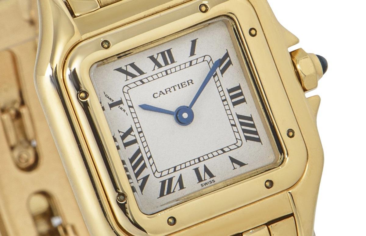 An iconic yellow gold 22mm Panthere by Cartier, featuring a silver dial with Roman numerals, sword-shaped hands and a secret Cartier signature at X. The bezel is fixed and made of yellow gold and the crown is set with a single cabochon.

Both the