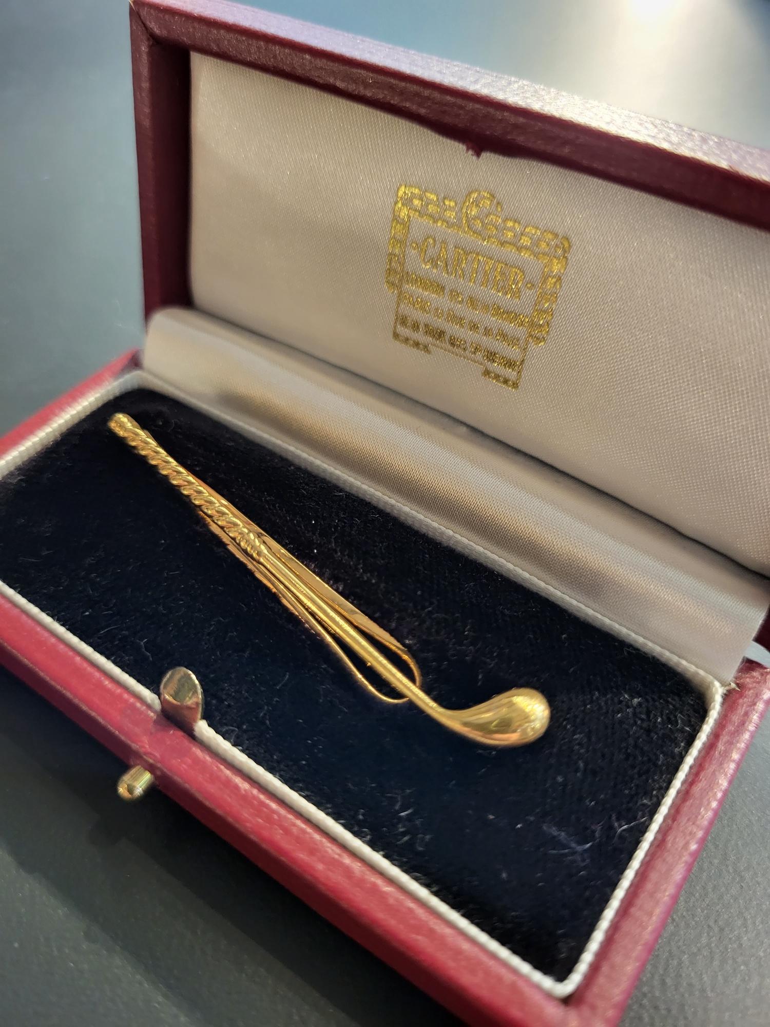 Cartier, Paris

An 18 carat gold tie clip in the form of a stylized 'Wedge' golf club, with twisted rope-style grip. Hand engraved 'Cartier Paris' to the reverse and twice struck with French poinçon marks and numbered ‘P9853‘.

The clip is set
