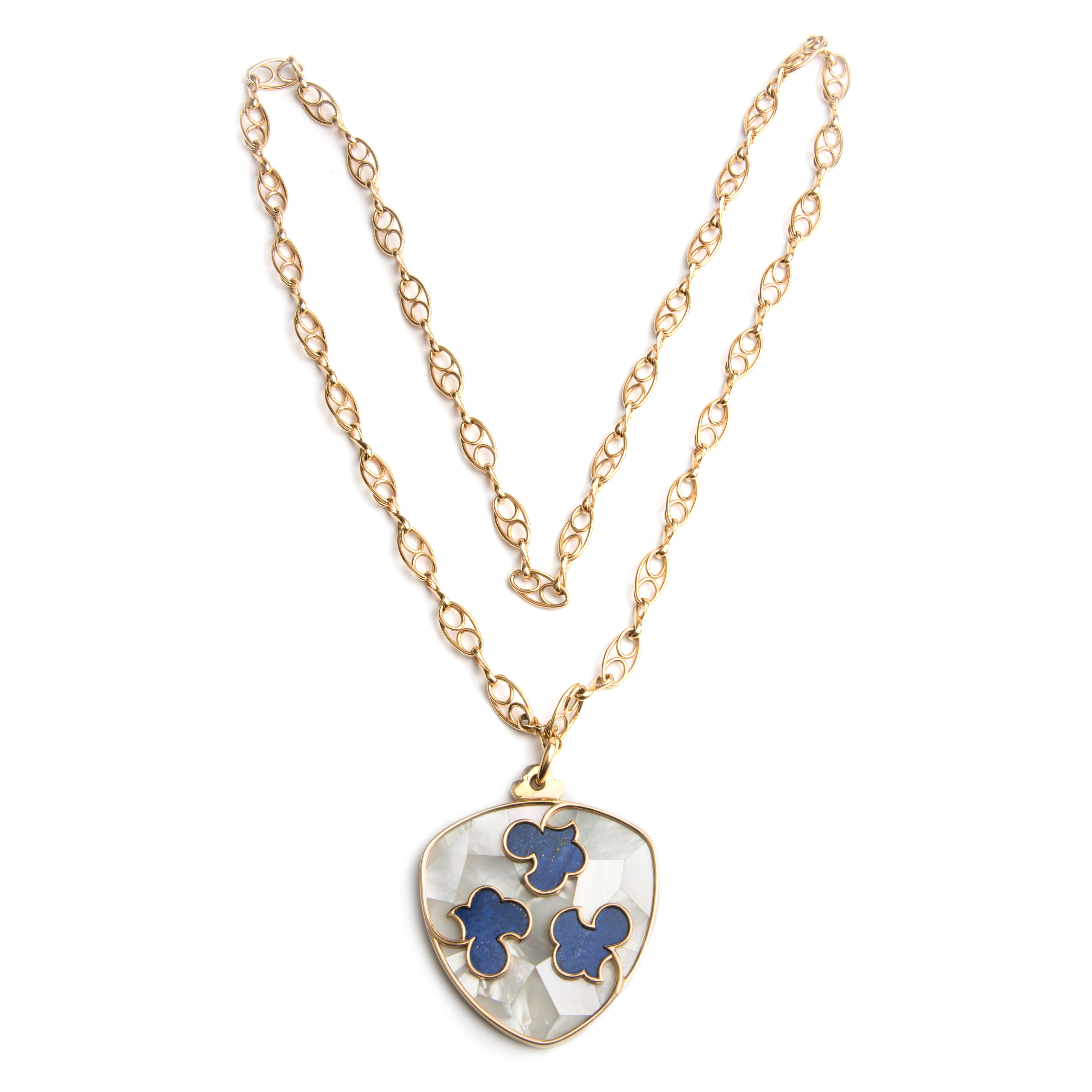 A pendant necklace, designed in the shape of a shield, decorated with lapis lazuli floral motifs on a mother of pearl marquetry font, suspended from a handcrafted link chain.
The pendant signed Cartier Paris, makers mark, French hallmarks, numbered