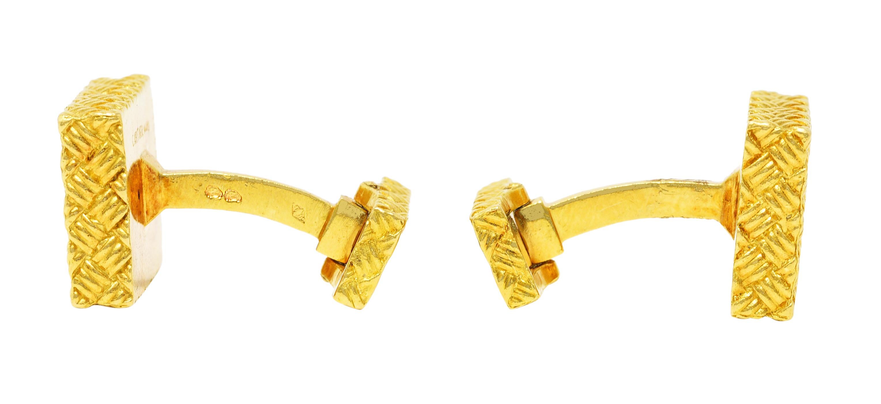 Bar style cufflinks terminate as two rectangular forms. With a grooved basket weave motif throughout. Smaller rectangle is hinged for fastening. Stamped with French hallmarks for 18 karat gold. Numbered and fully signed for Cartier, Paris. Circa: