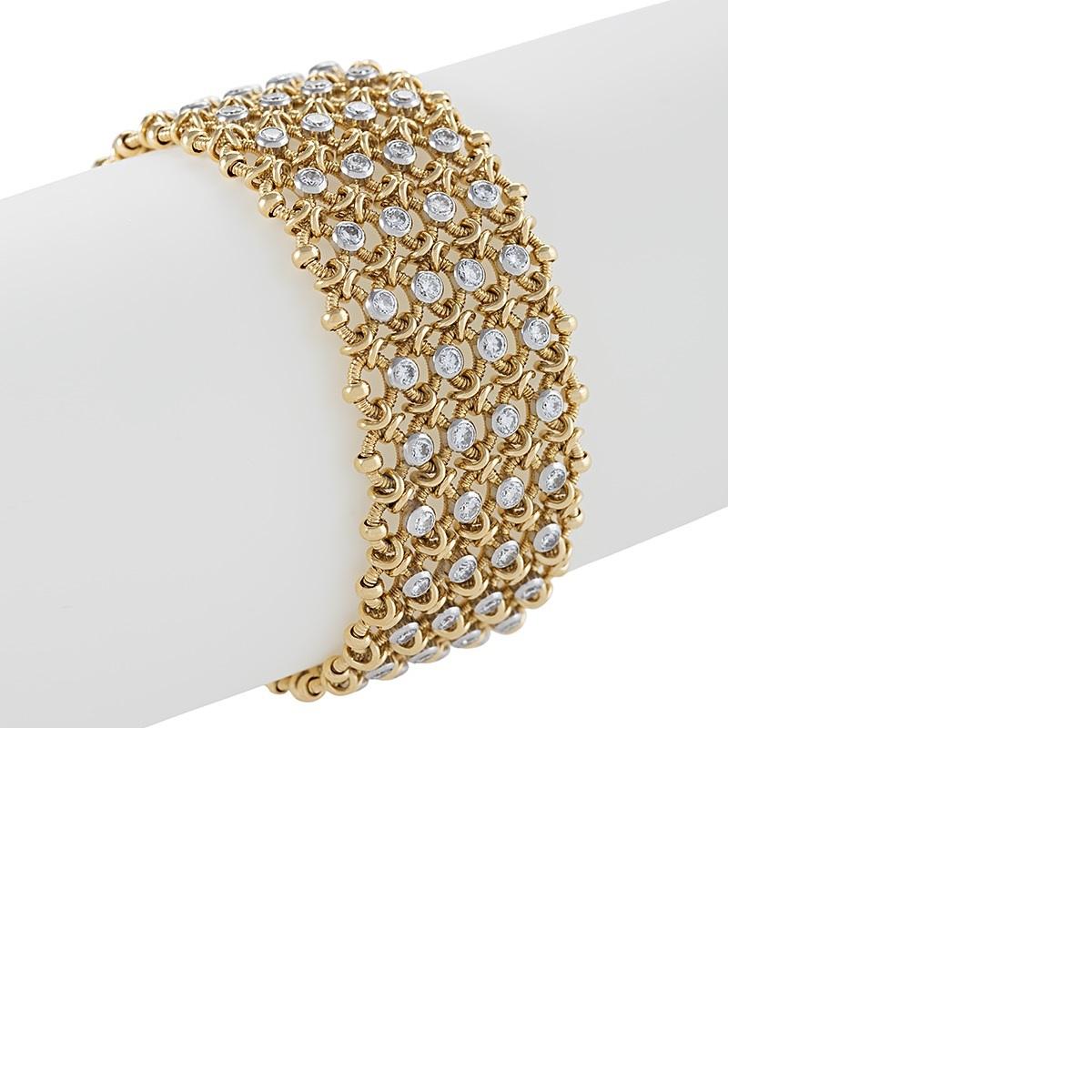 The sinuously fluid drape of this woven mesh link gold Cartier Paris bracelet, sprinkled with diamonds, sheaths the wrist with a light touch, as if it is made of the finest chainmail. Ribbed circular links are woven together with polished ties and