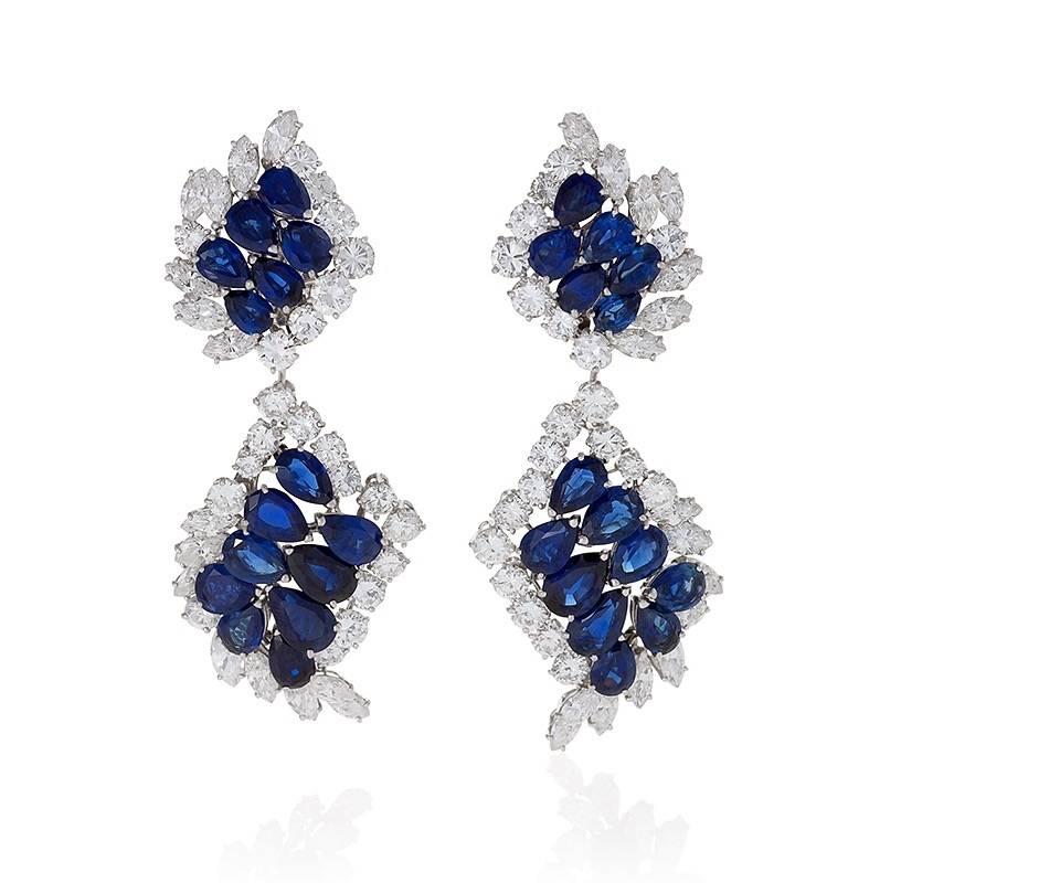 The flowing design of these Cartier sapphire and diamond earrings frames the face with a radiant energy. A tessellation of blue sapphires bounded by dazzling colorless diamonds set in platinum creates a sense of expanding fluidity and movement. The