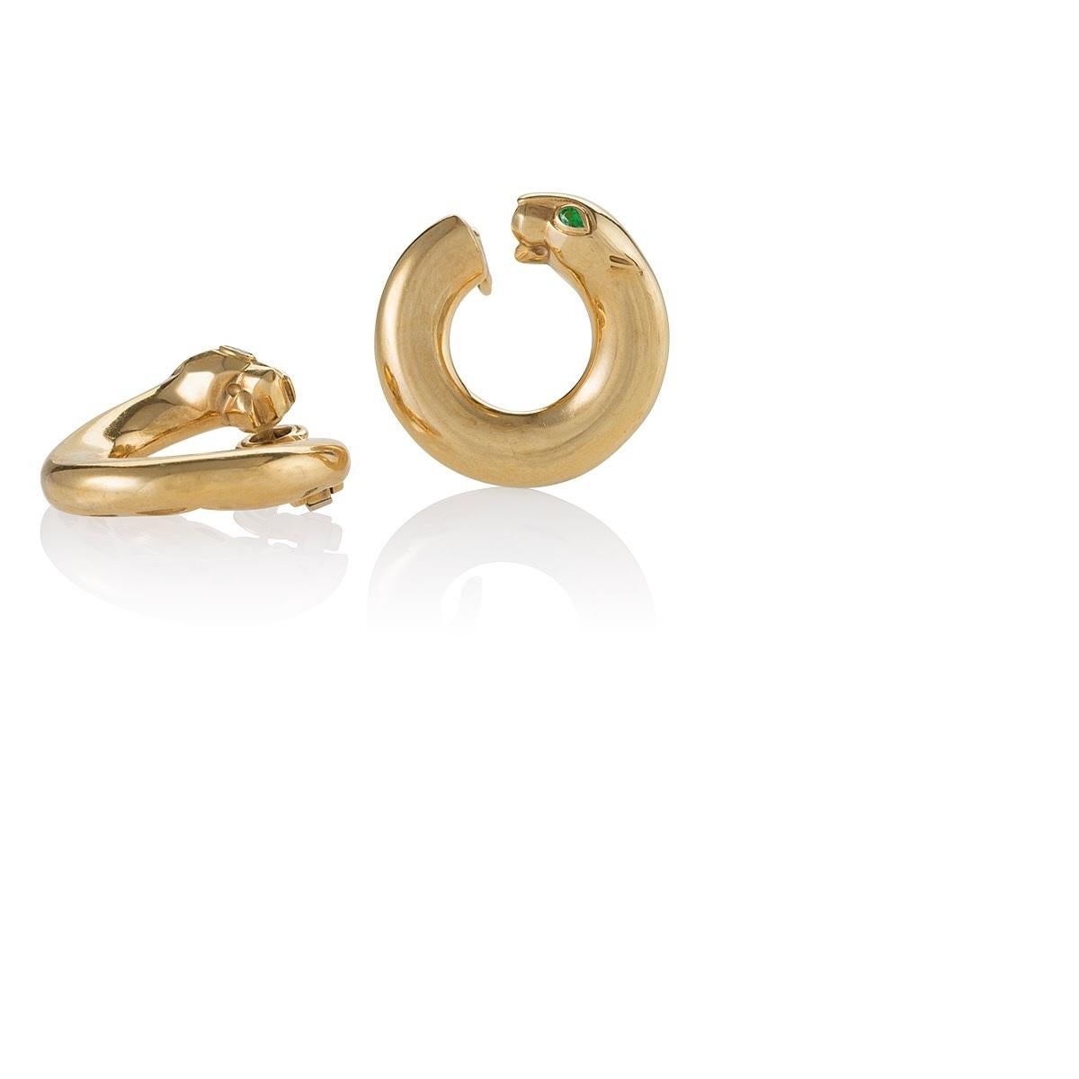 A pair of French Late-20th Century 18 karat polished gold earrings with emeralds by Cartier. The earrings have 2 pear cut emeralds with an approximate total weight of .10 carat. The earrings are designed as hoops ending with the distinctive panther
