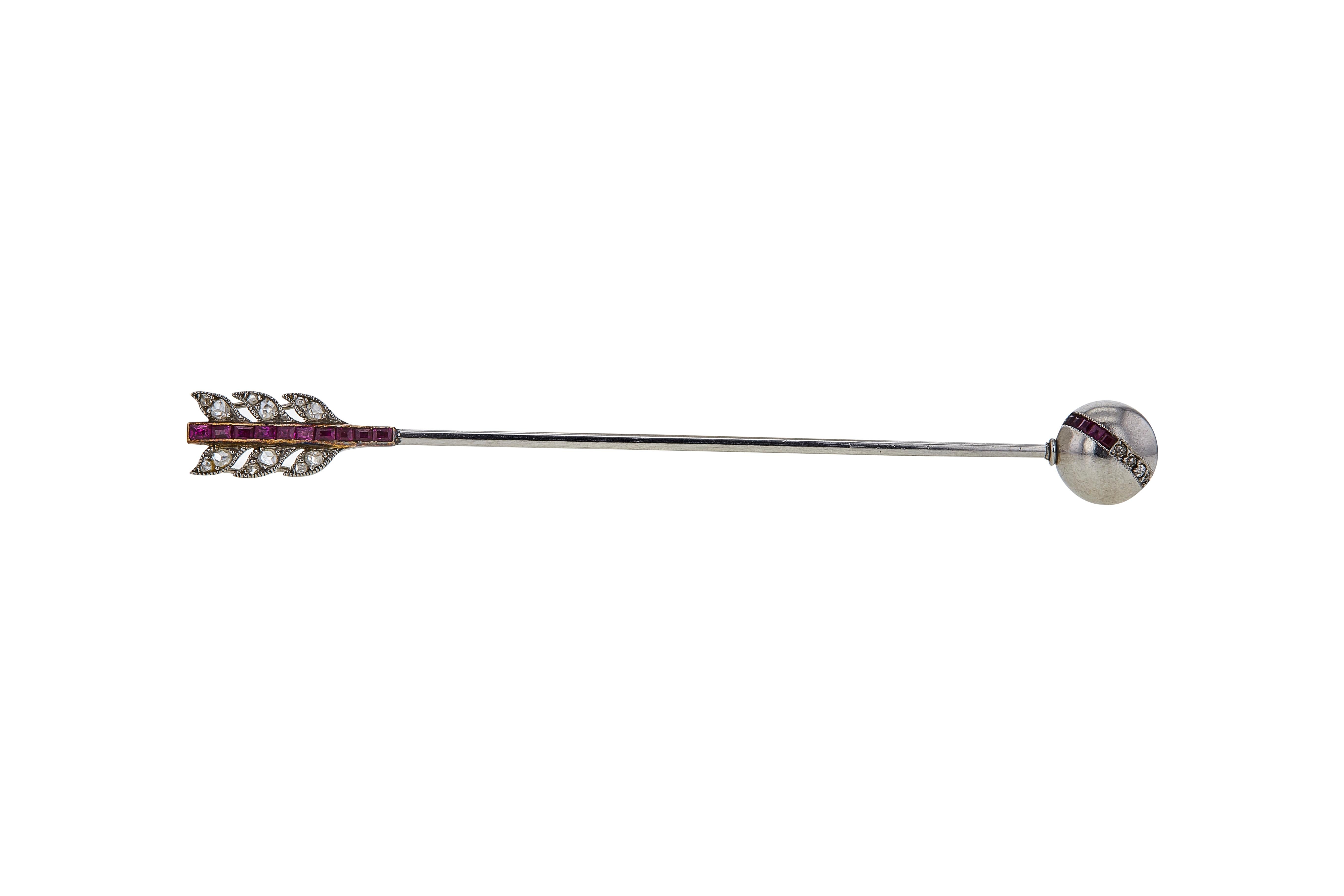 Authentic Art Deco Cartier jabot pin designed as an arrow with a spherical tip. Crafted in platinum and 18 karat yellow gold, the jabot pin is elegantly set with calibrated rubies and approximately 22 rose-cut diamonds weighing an estimated 0.20