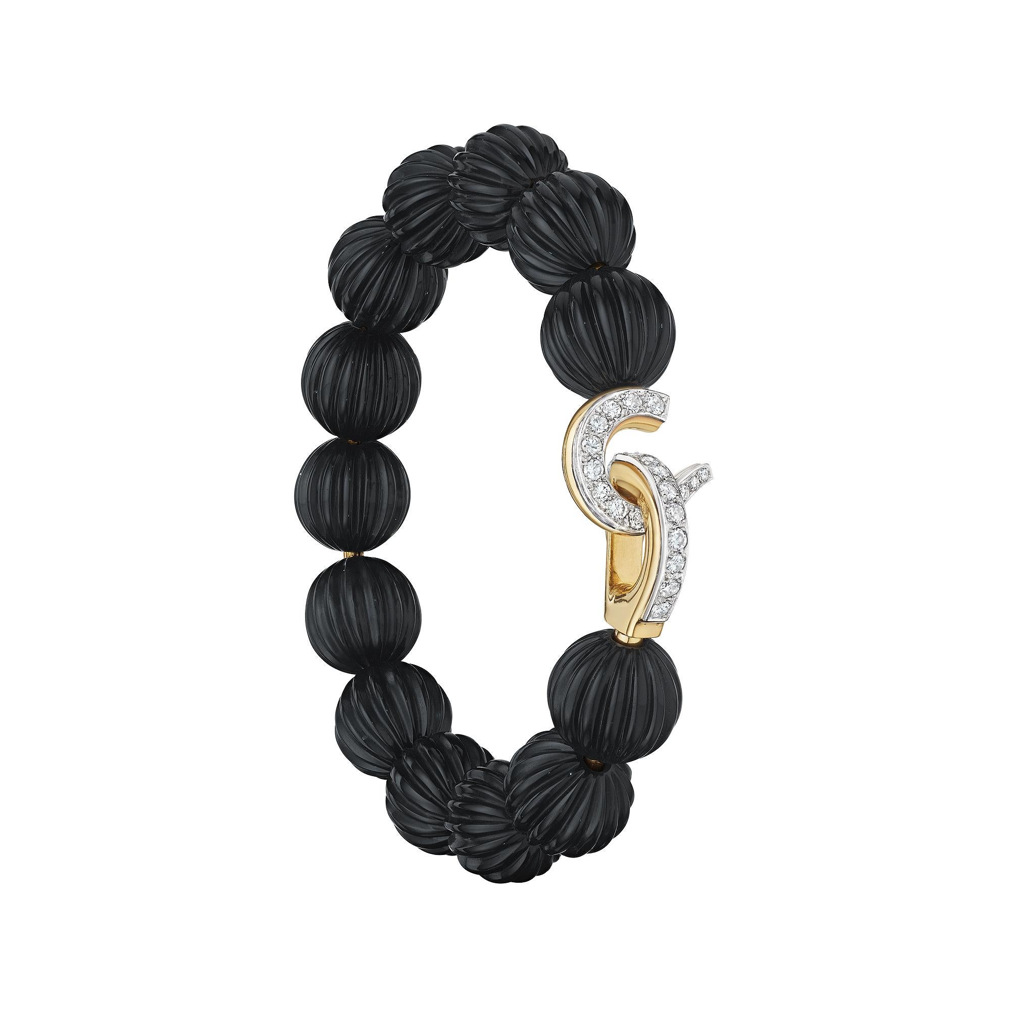 Elegantly dancing around the wrist these 13 carved black onyx melon shaped beads create a compelling Cartier Paris vintage diamond and 18 karat yellow gold bracelet that is both collectible and hard to resist.  The eye-catching diamond hook and eye