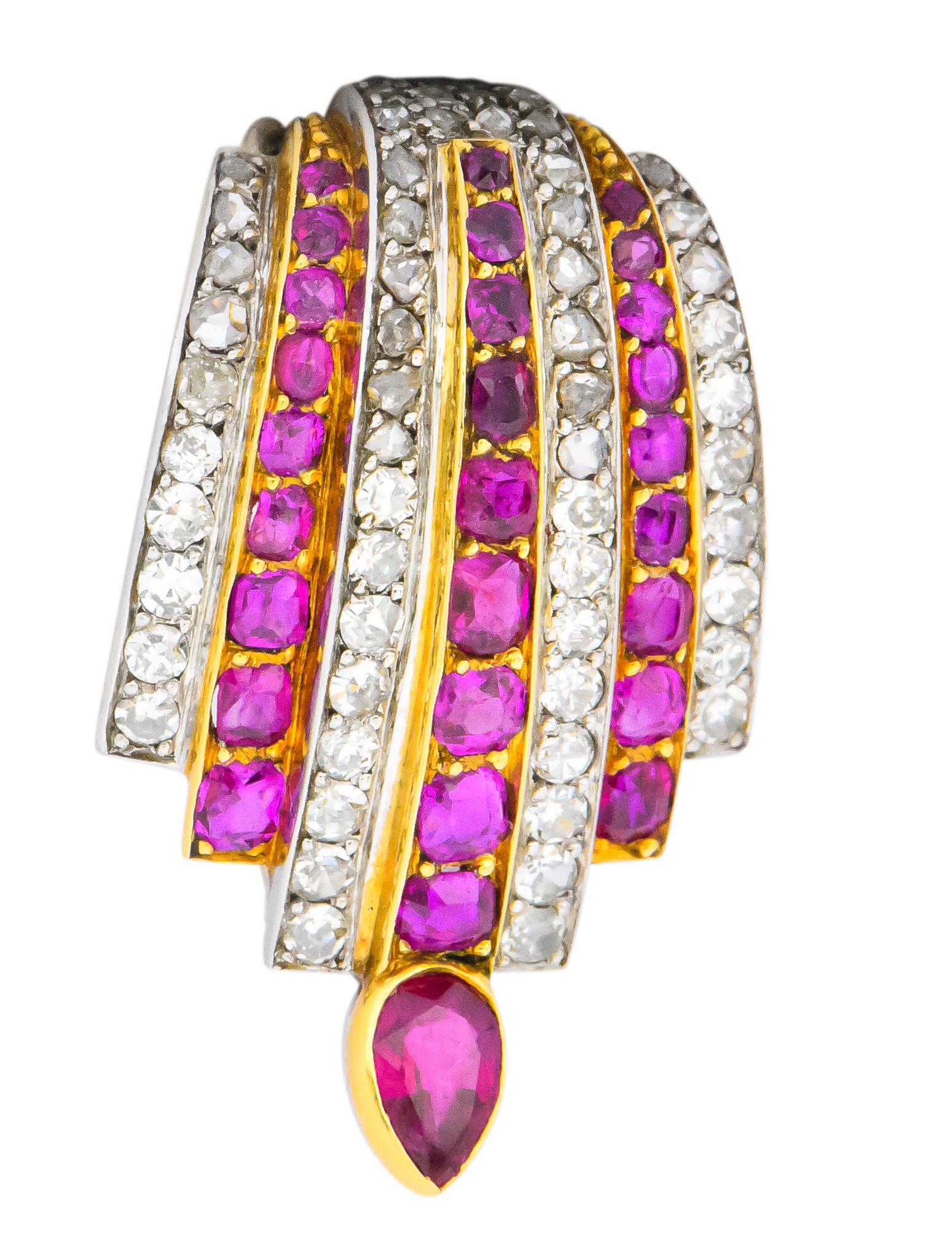 Brooch is designed as a domed formation comprised of seven rows of diamonds and Burmese rubies, alternating

Rows taper in length as a cascading motif that terminates as a bezel set pear cut Burma ruby

Cushion cut rubies are bead set in gold and