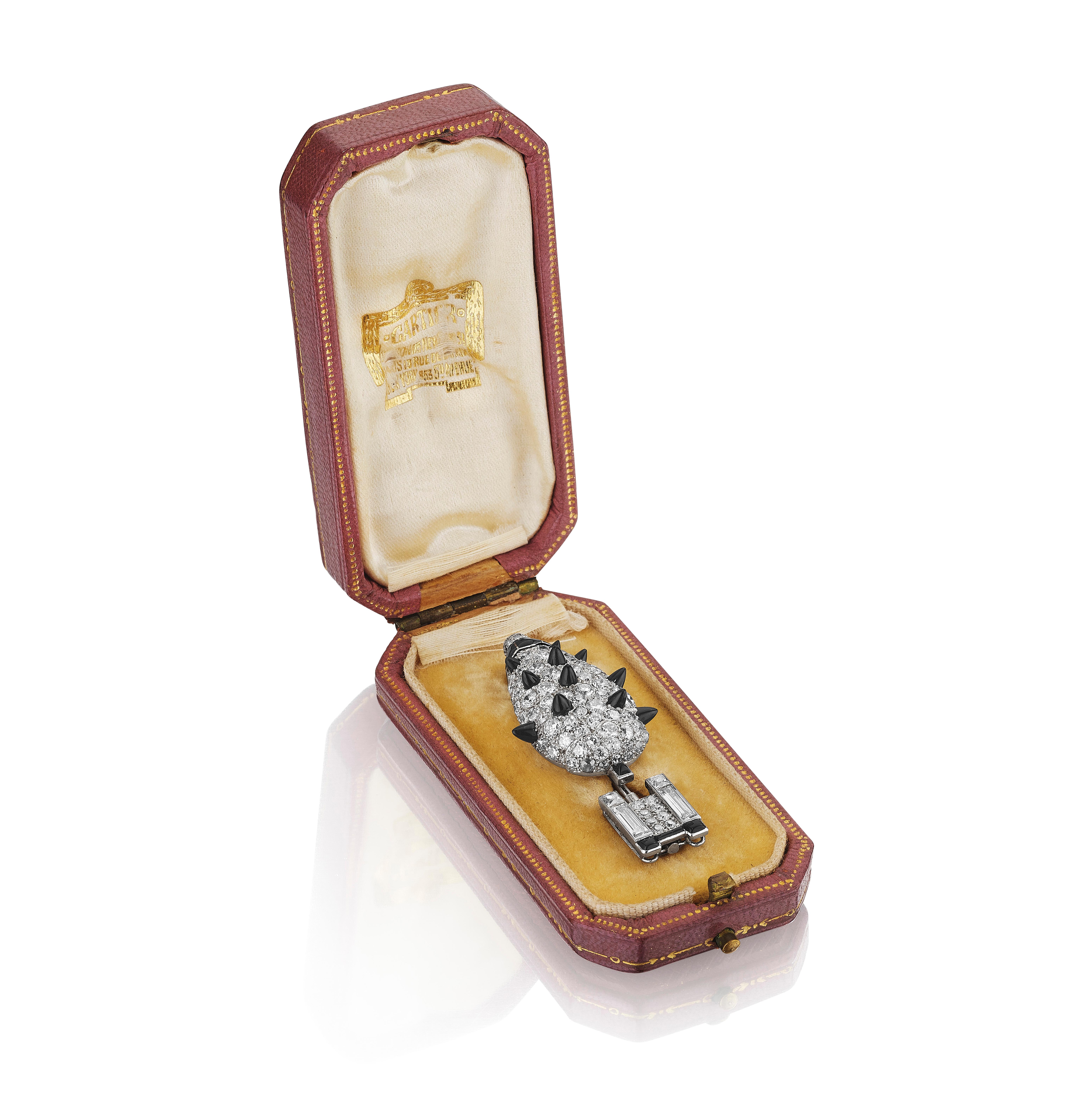 A brooch designed as a potted topiary set throughout with European-cut diamonds, interspersed with French-, baguette-, and single-cut diamonds, accented with black onyx detailing, completed with black enamel accents and a reverse-set diamond at the