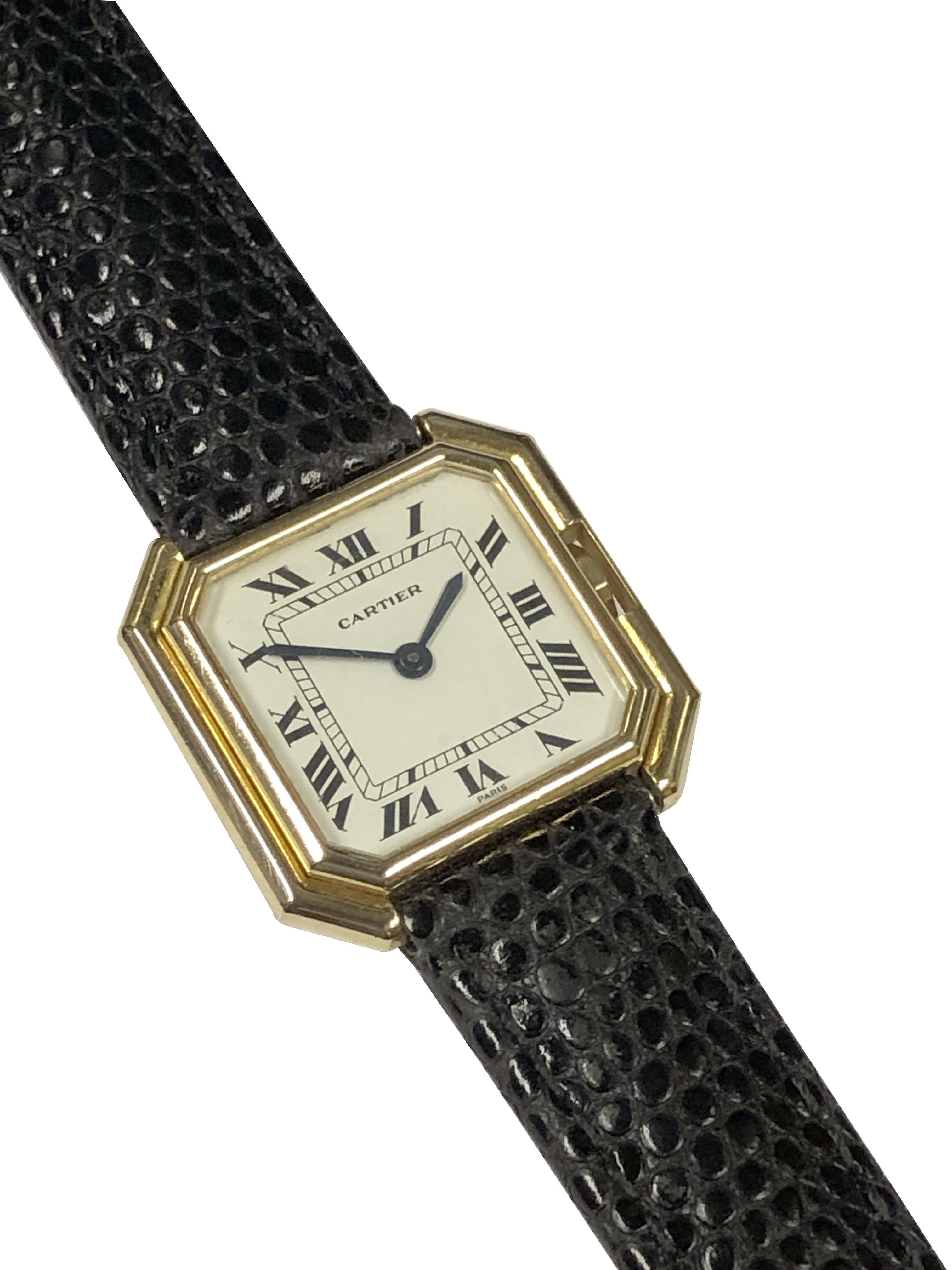 Circa 1980 Cartier Paris Centure Collection Wrist Watch, 18k Yellow Gold 27 X 27 M.M. 2 Piece stepped case. 17 jewel mechanical, manual wind movement. White Dial with Black Roman numerals. New Black Lizard grain strap. watch length 7 3/4 inches.