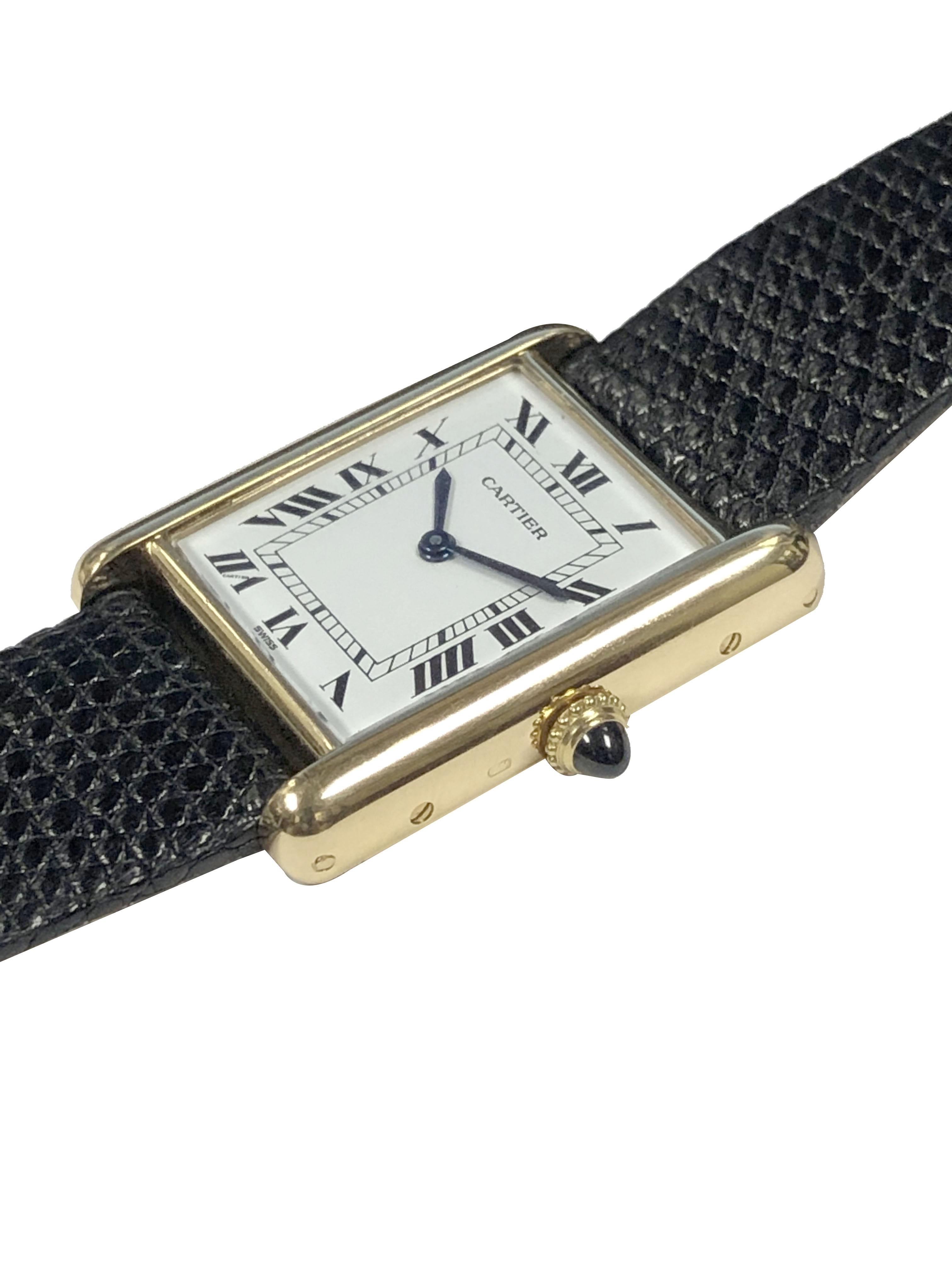 Circa 1990 Cartier Classic Tank Wrist Watch,  30 x 23 M.M. 18k Yellow Gold 2 piece case, Mechanical, Manual wind movement, Sapphire Crown, White dial with Black Roman numerals. New Black Lizard strap with a Gold plate Cartier tang buckle. Watch