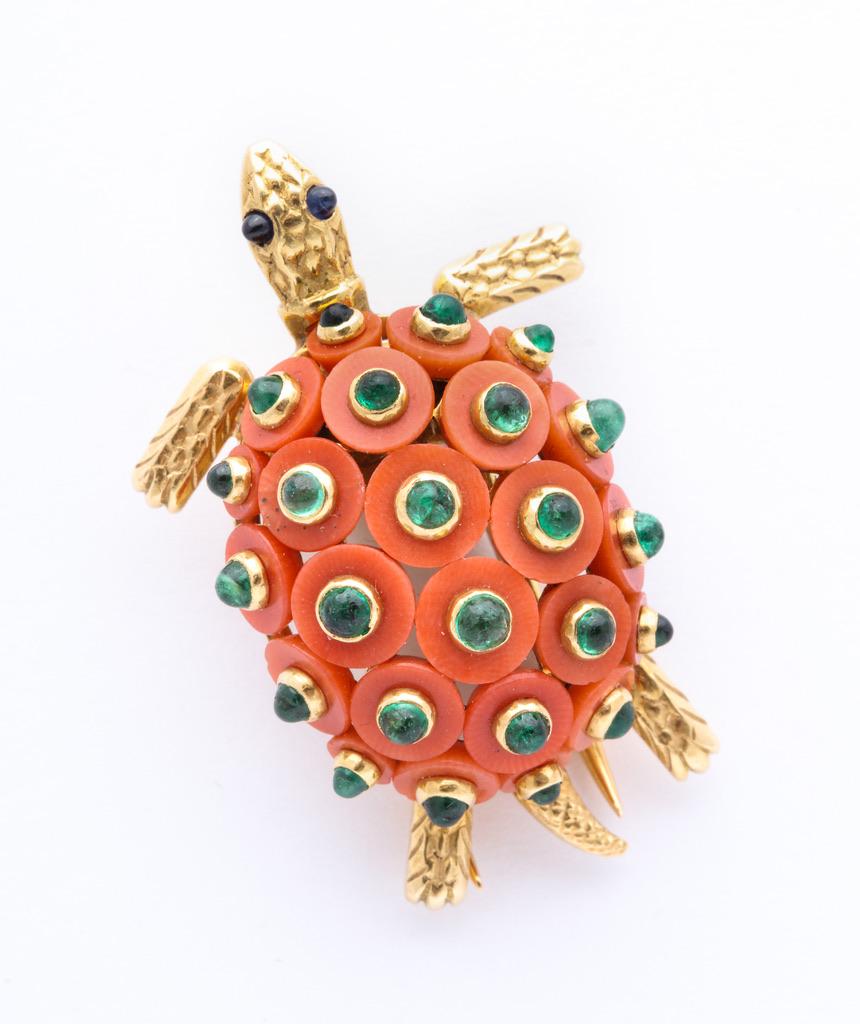 This exquisite work by Cartier features coral discs set with cabochon emeralds, and is further accented with  cabochon sapphire eyes.  
Signed, numbered and properly hallmarked for authenticity.
Circa 1960
Made in France.