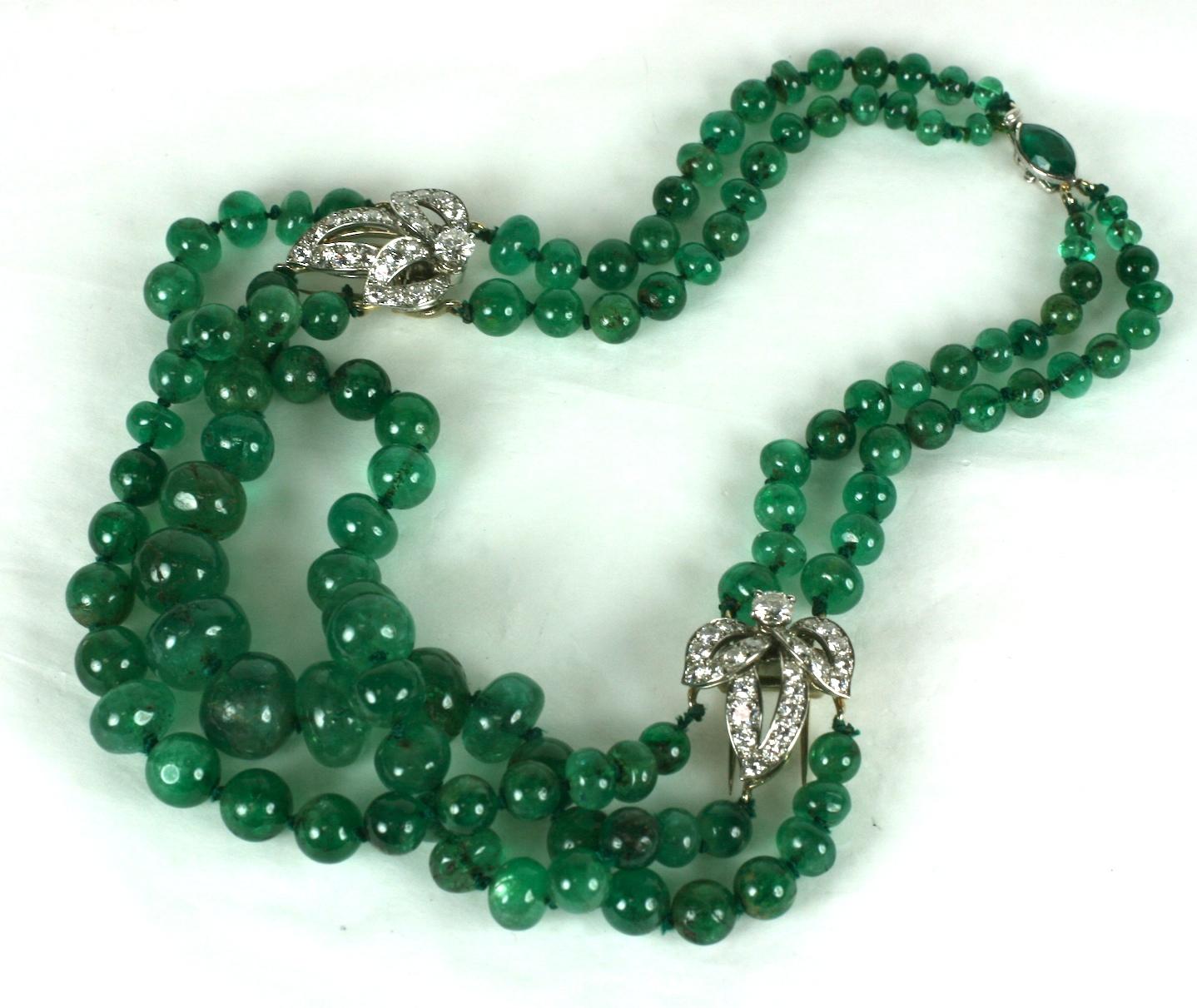 Striking Cartier, Paris Diamond Clip and Emerald Bead Necklace from the 1950's. A pair of detachable leaf form clips are the stations to which the graduated emerald beads are strung. A lovely marquise shaped 1 carat Columbian emerald forms the clasp