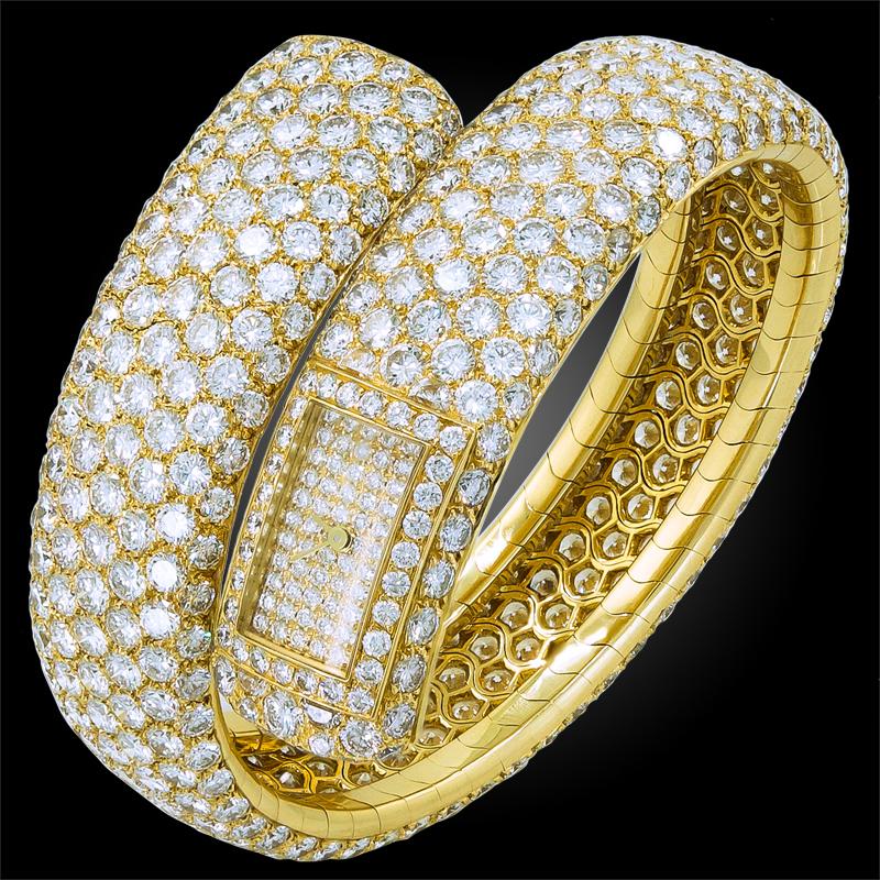 A remarkable wristwatch by Cartier that dates back to the 1980s, shaped as a coiled bangle thoroughly embellished with brilliant pave set diamonds crafted in 18k yellow gold, featuring a diamond filled rectangular dial. An exceptional piece for the