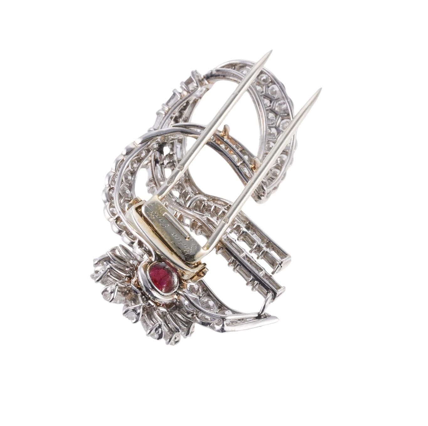 Exquisite platinum and gold Cartier Paris flower brooch, set with center oval ruby (approx. 6.5 x 5.4mm), surrounded with a total of approximately 6.00 carats in G/VS diamonds. Brooch measures 48mm x 26mm. Marked with plat and gold punchmarks on the