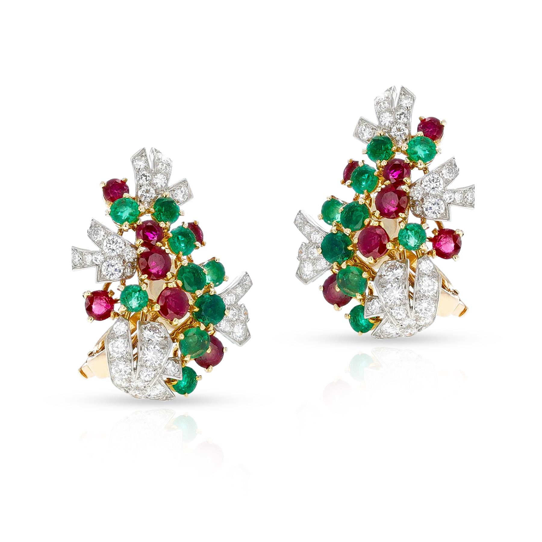An elegant pair of earrings by Cartier, Paris, which are set with round-shaped emeralds, ruby, and diamonds in platinum and yellow gold. Each earring is signed “Cartier Paris,” numbered, and stamped with the maker’s mark. The length is 1.20 x 0.85