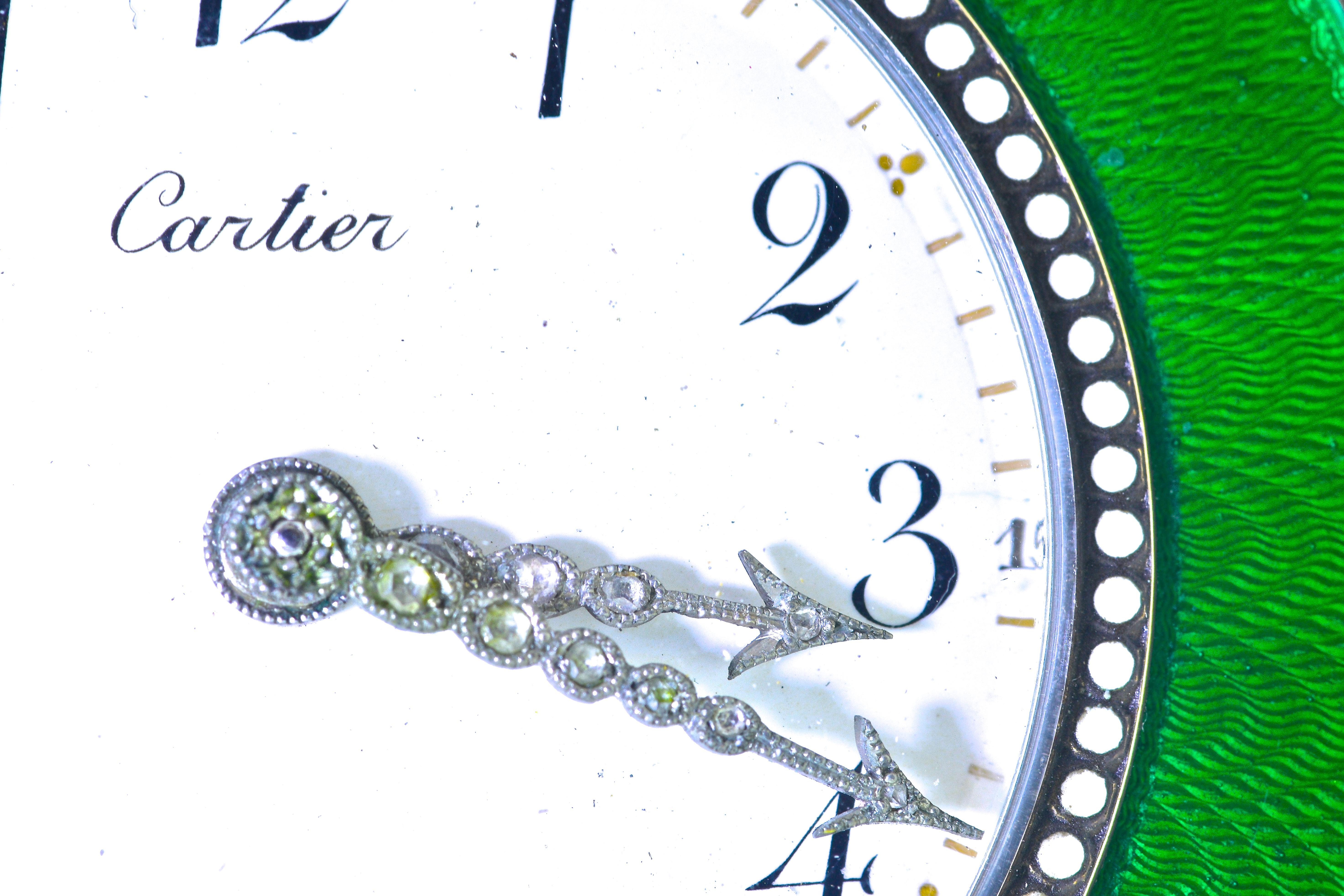 Cartier desk clock, Belle Epoque, circa 1914.   Green guilloche enamel, white opaque enamel and white enamel to simulate pearls around the dial.  Rose cut diamonds are set into the silver hands and in silver floral motifs.  This silver small clock,