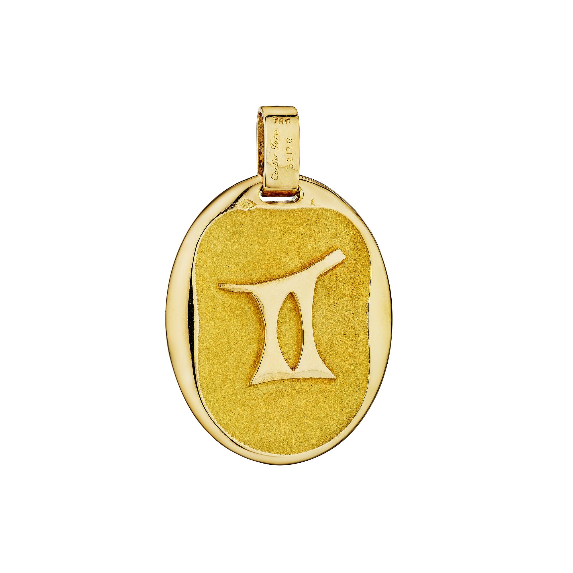 Fallo doppio. Questo raro ciondolo ovale modernista di Cartier Paris Georges L'Enfant Gemini presenta il doppio simbolo celeste di due persone (gemelli) sul davanti e il numero romano per due sul retro. Oro giallo 18 carati. Firmato Cartier Paris e